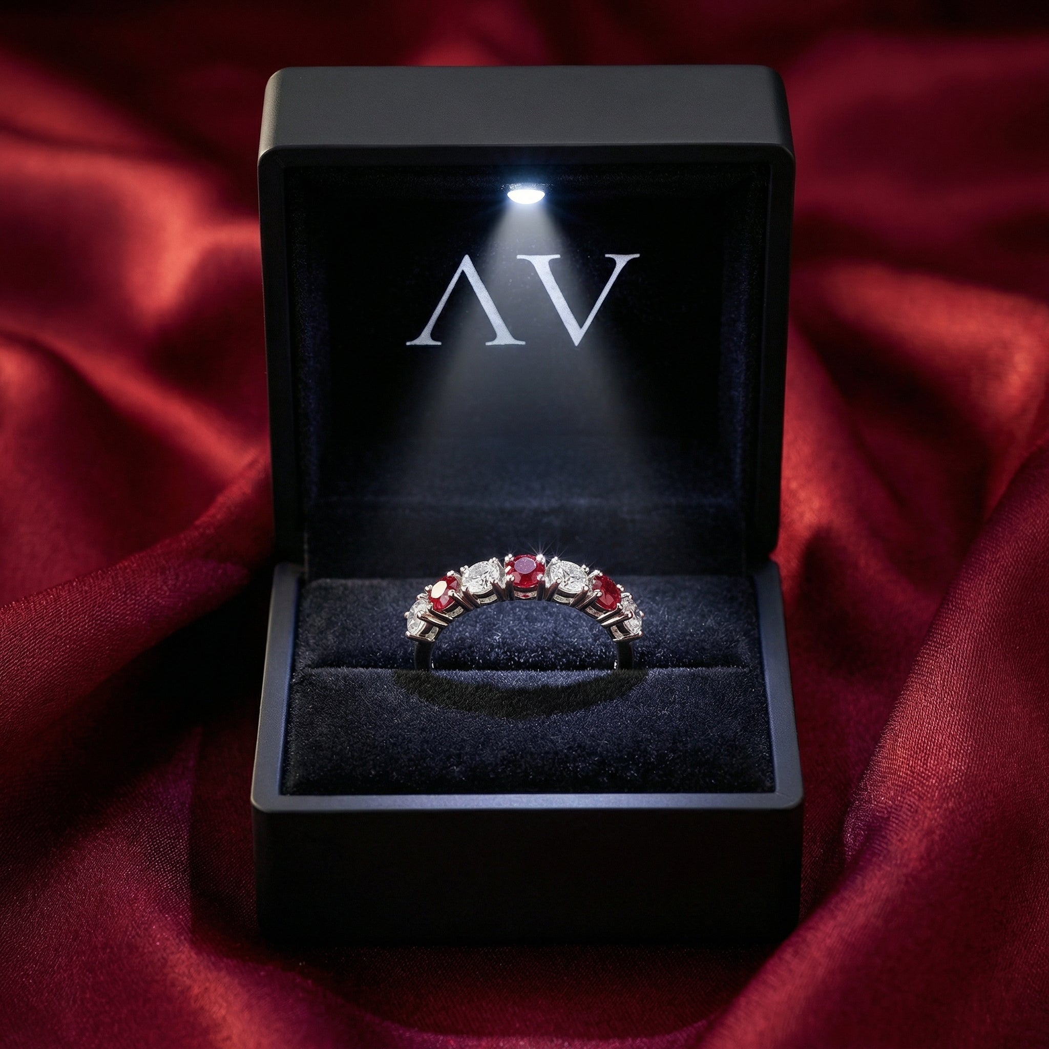 Rubielle sterling silver eternity ring displayed in a black LED-lit gift box on red satin fabric.
