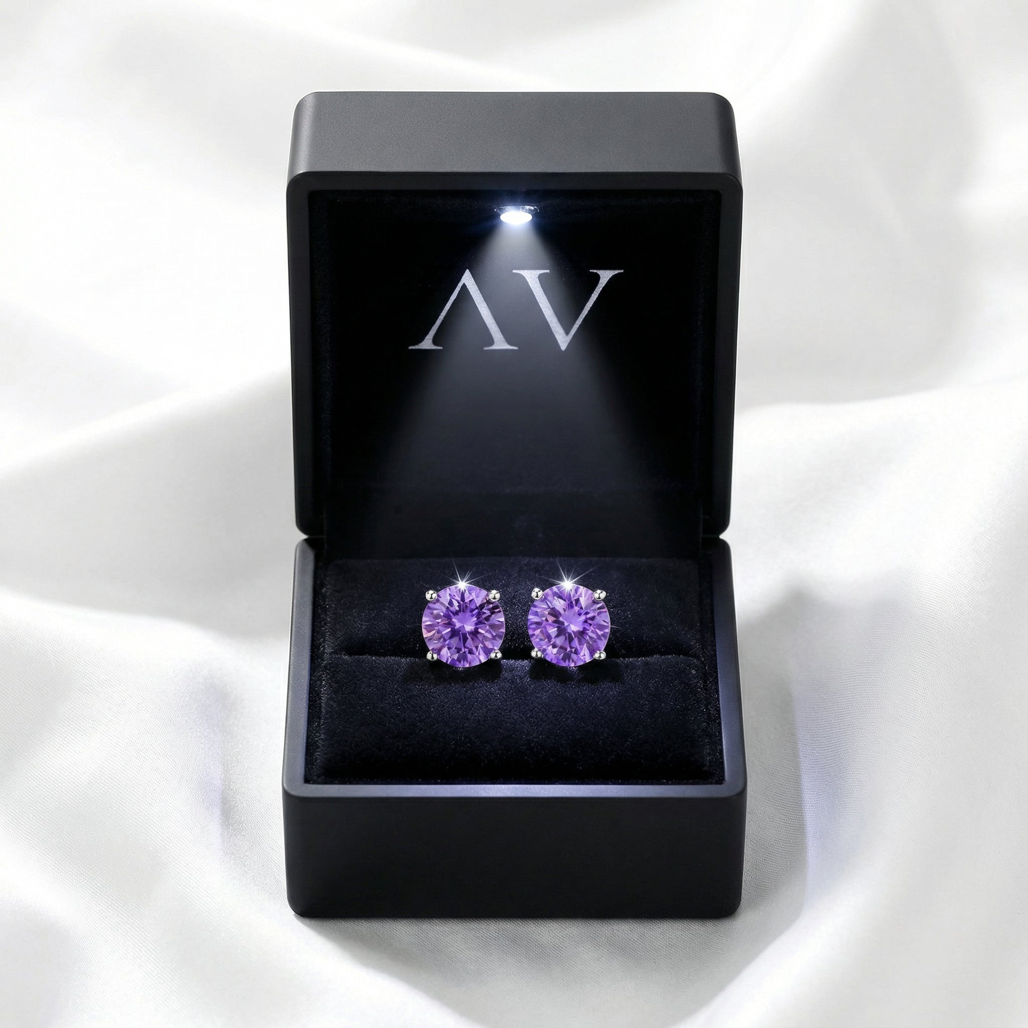 Round cut simulated amethyst sterling silver stud earrings in a premium black LED-lit jewelry gift box.