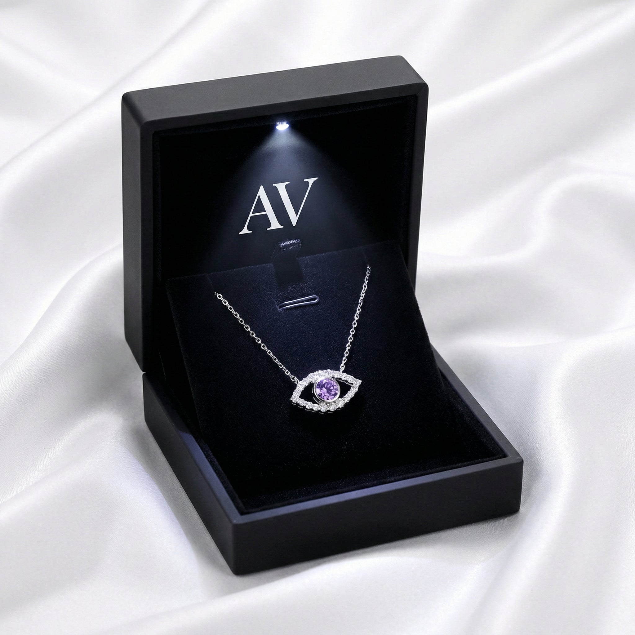 Sterling silver amethyst evil eye necklace presented in a black LED-lit jewelry gift box on white satin.