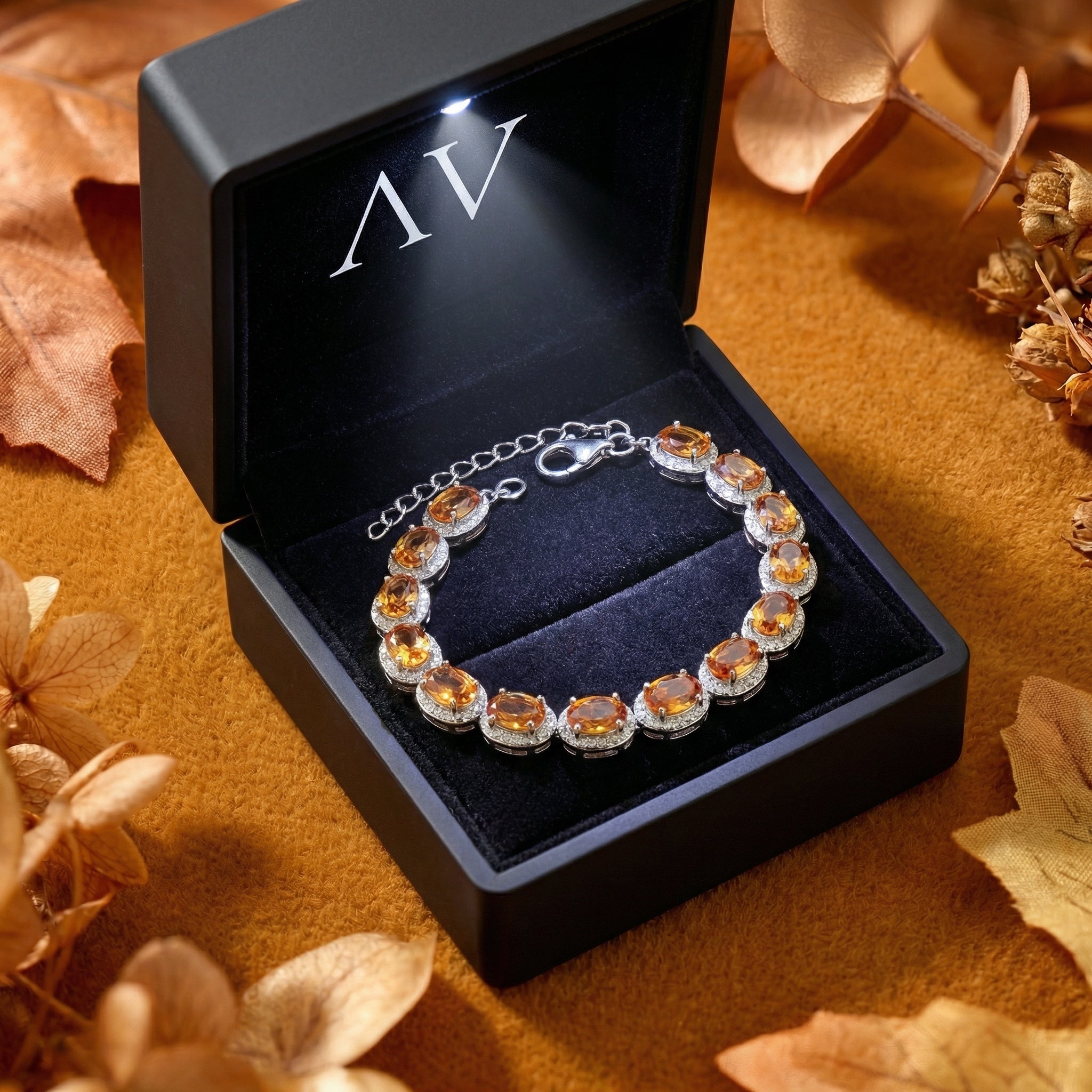 Sterling silver Alizae halo bracelet with simulated topaz stones in a lighted black jewelry gift box.