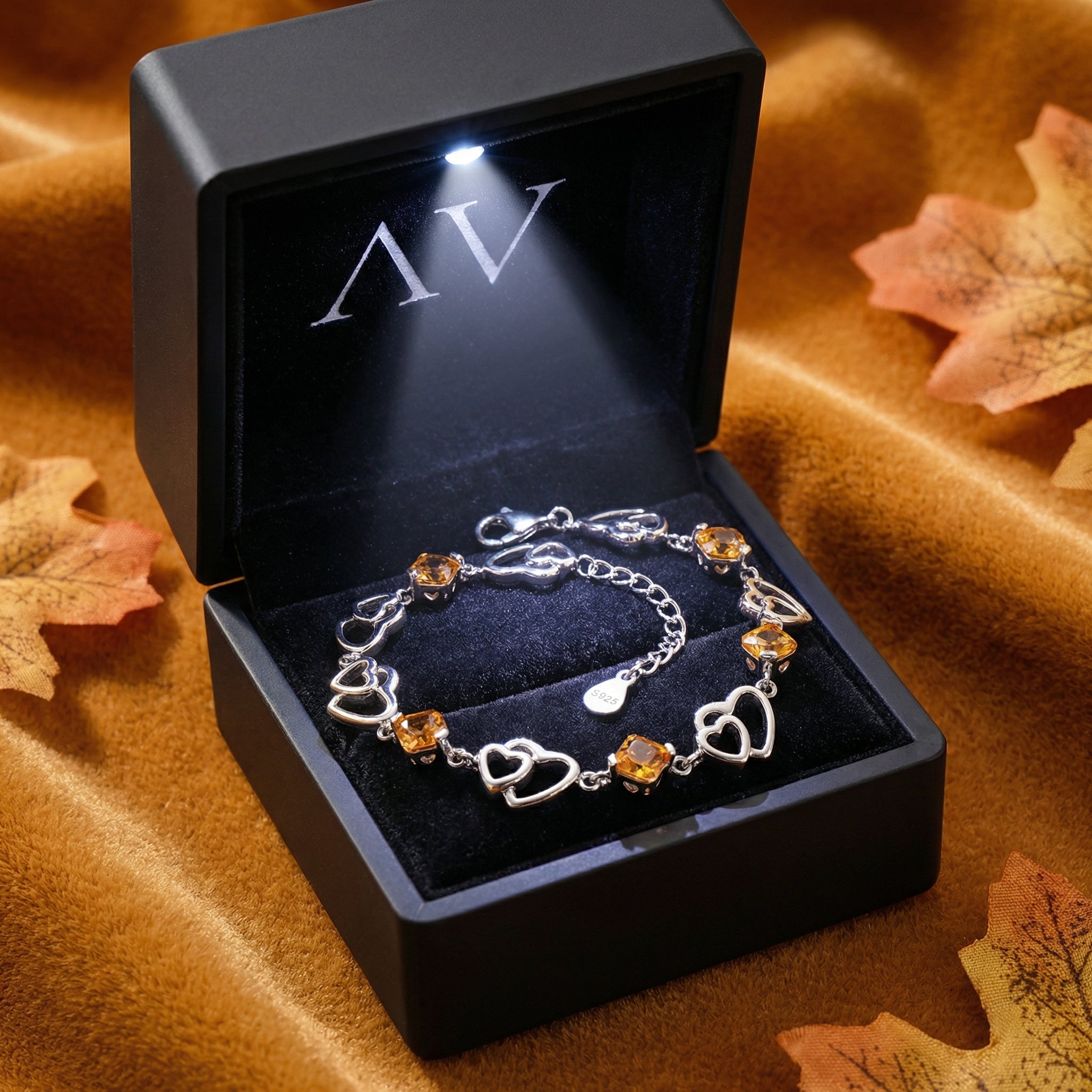 S925 sterling silver heart bracelet with simulated topaz stones inside a premium black LED-lit jewelry gift box.