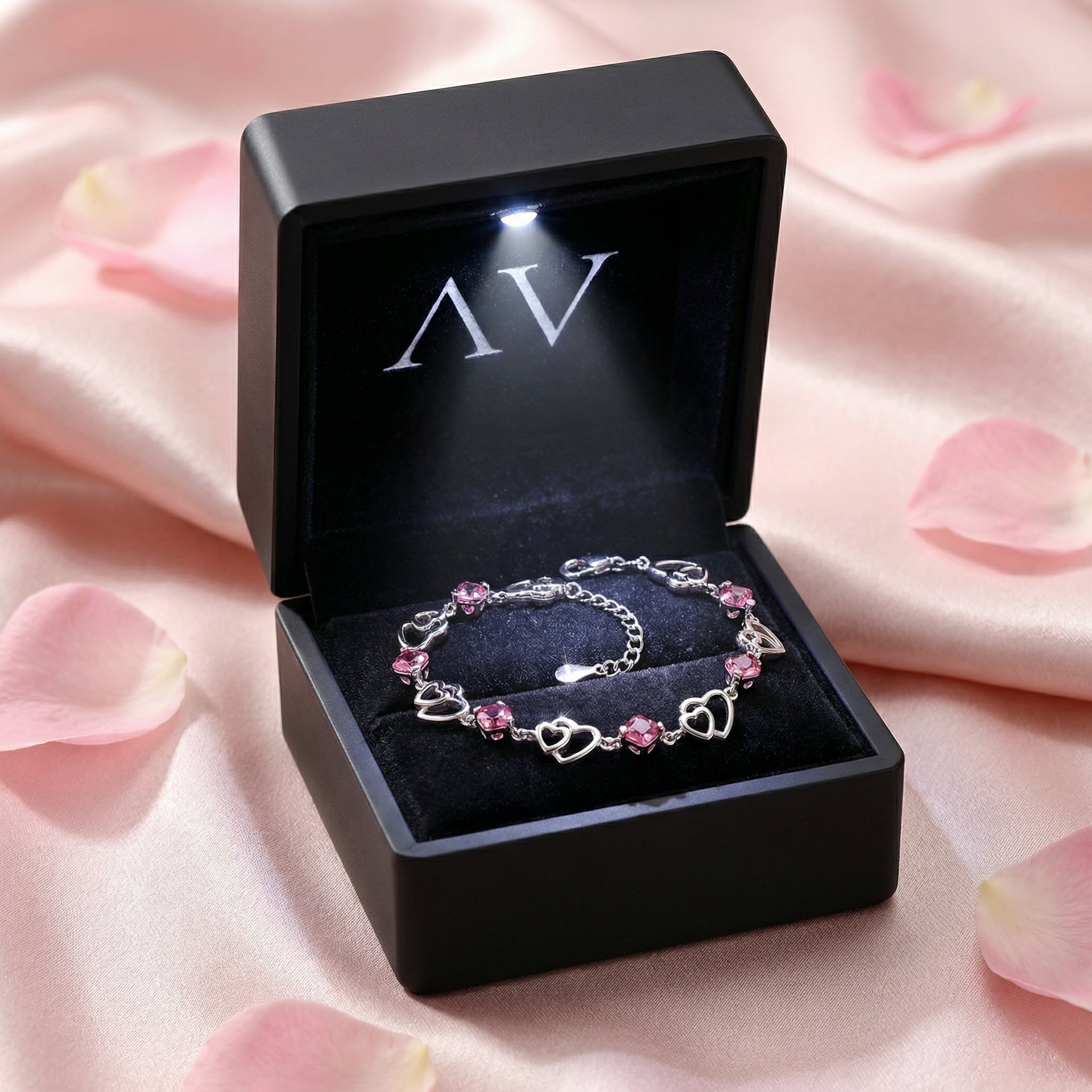 S925 sterling silver heart bracelet with pink tourmaline in a black LED-lit jewelry presentation box.