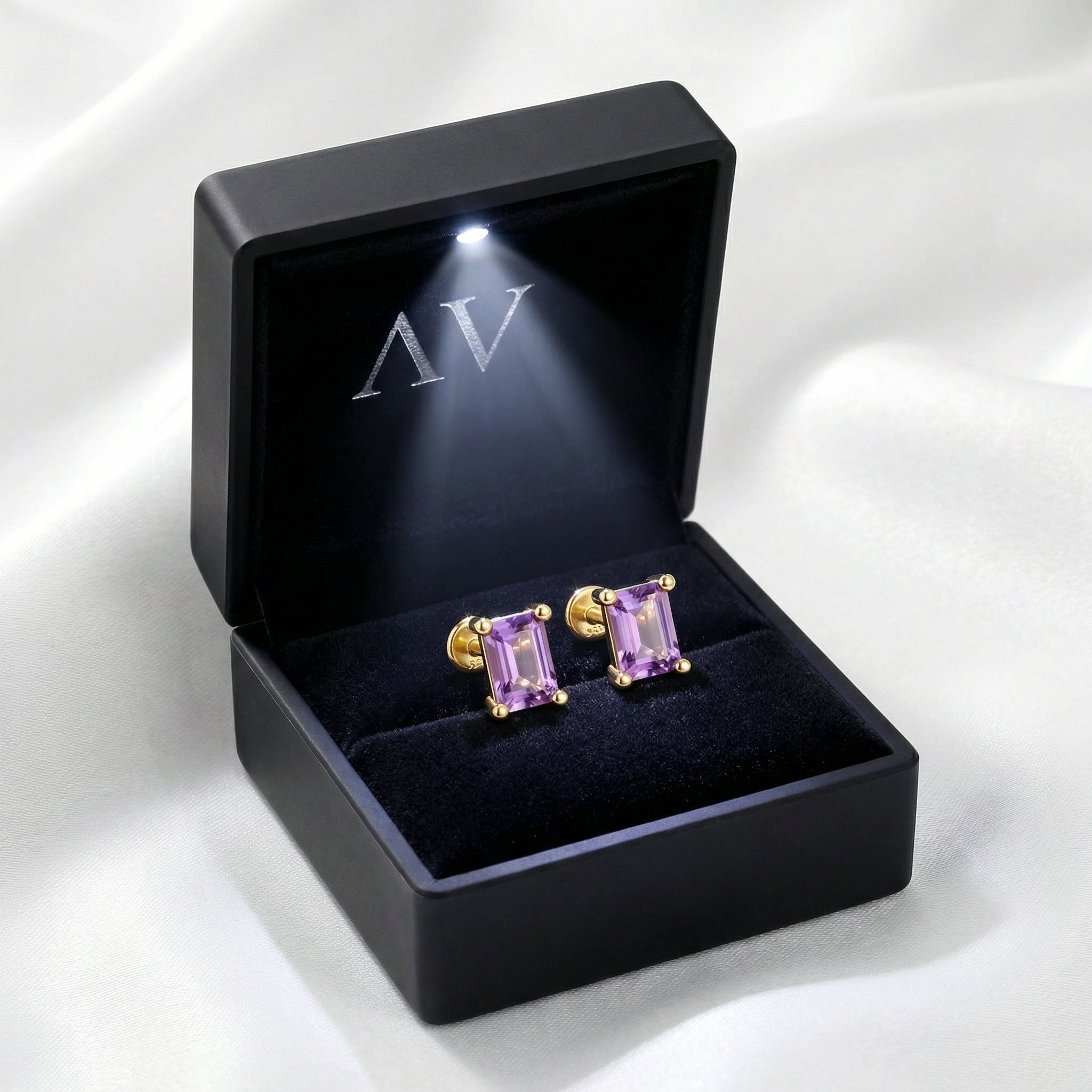 Emerald cut amethyst stud earrings in 18K gold vermeil presented in a black LED-lit jewelry gift box.
