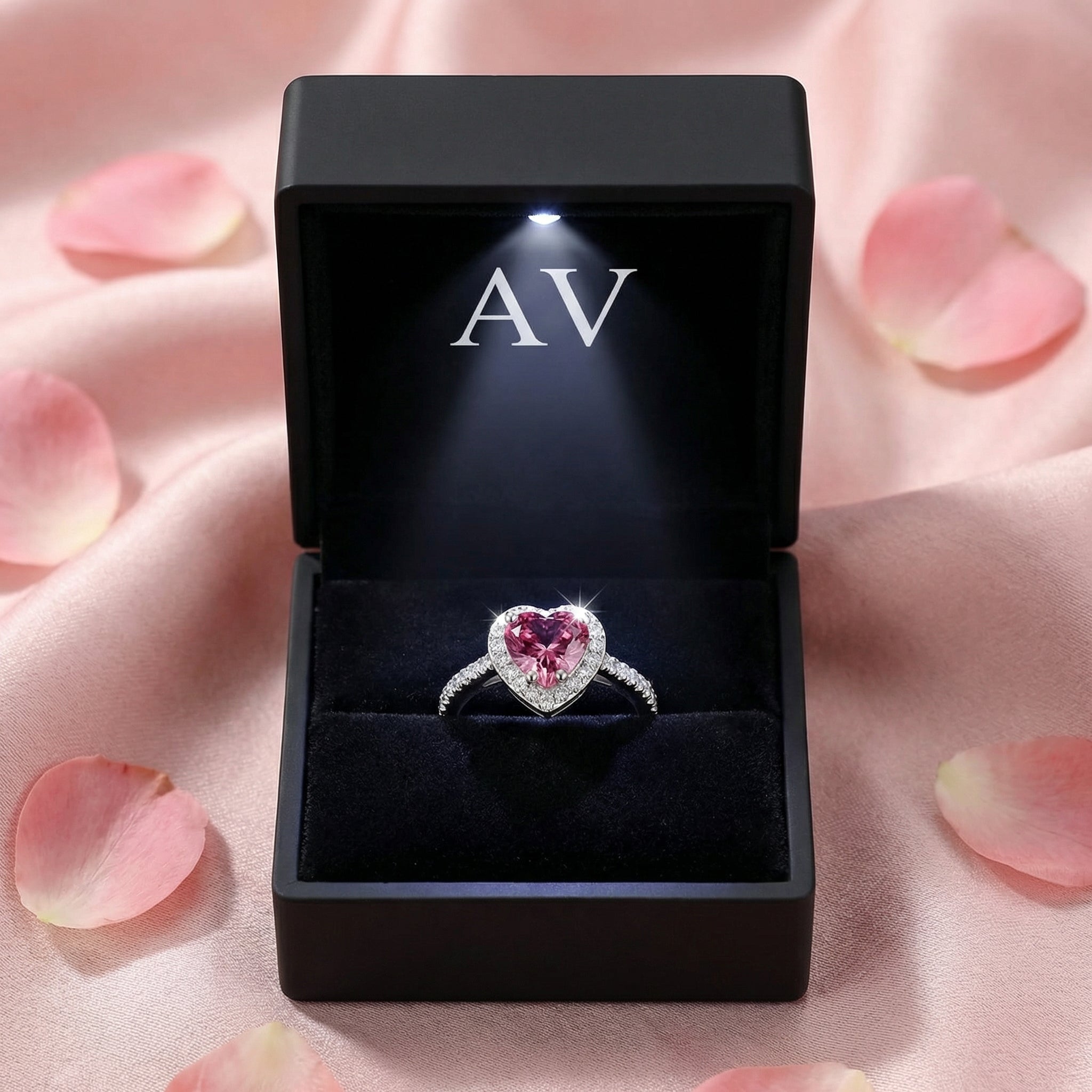 Heart-cut simulated pink tourmaline sterling silver ring in a black LED-lit gift box with petals.