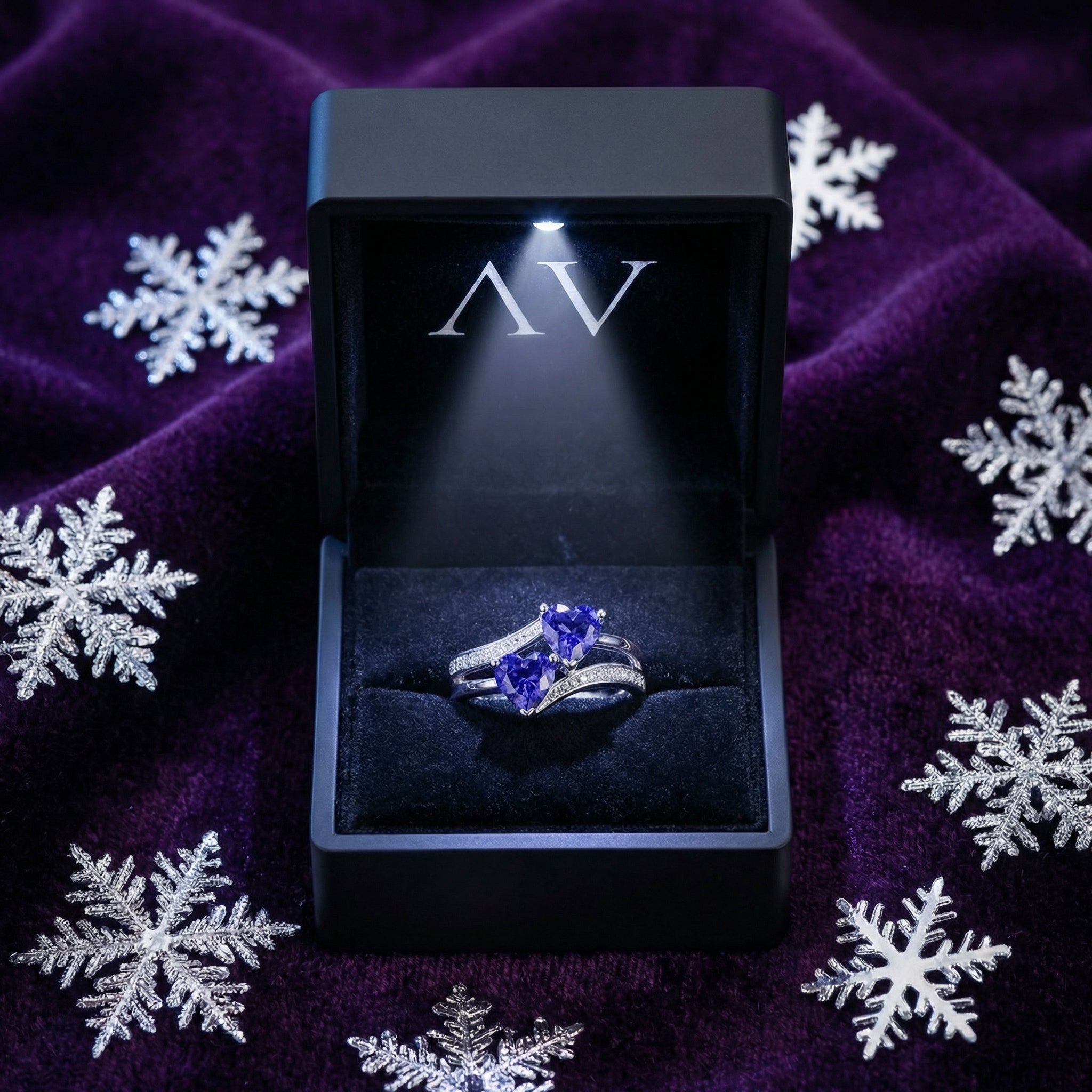 S925 sterling silver heart ring with blue simulated tanzanite in a lighted black gift box on purple velvet.