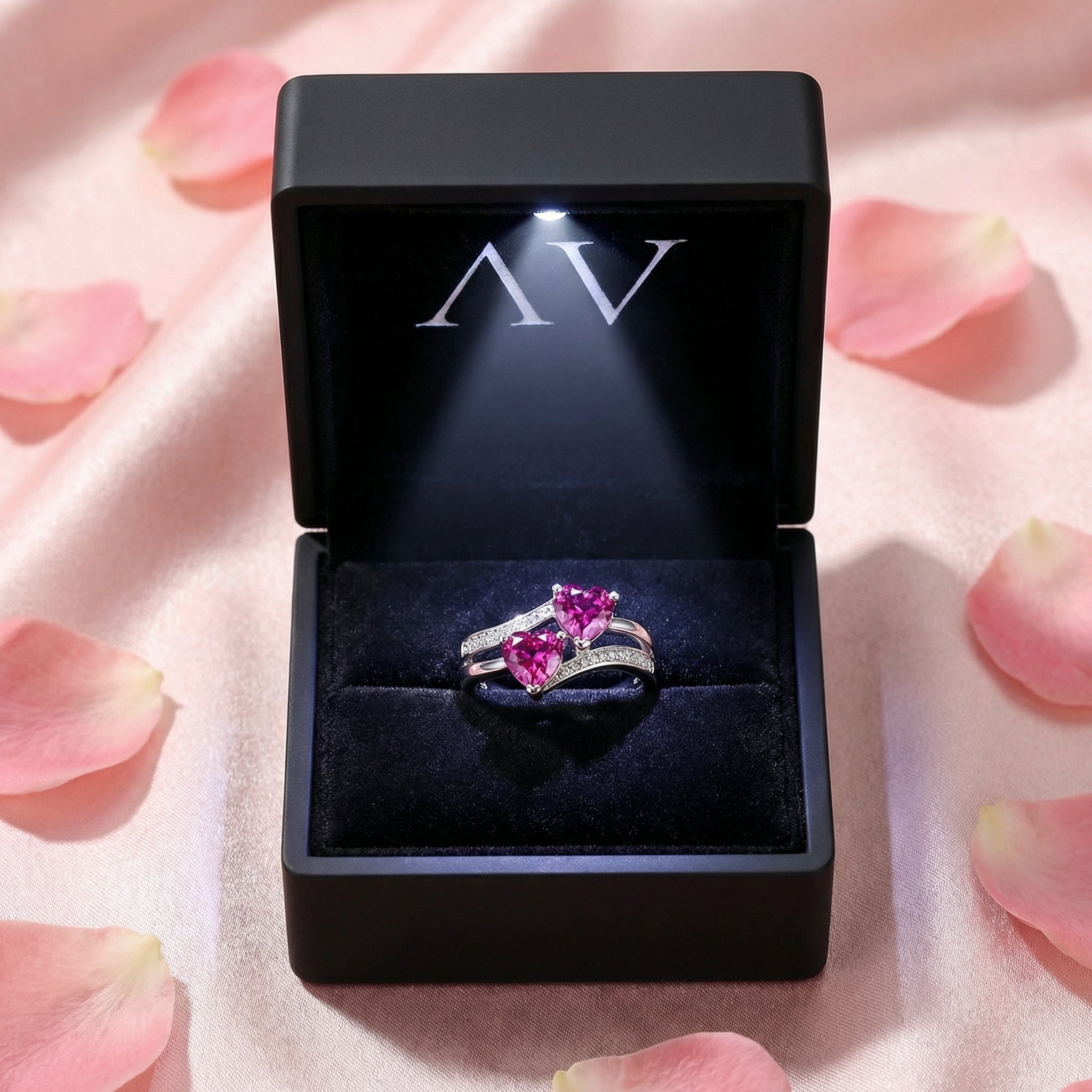 S925 sterling silver pink tourmaline heart ring presented in a black lighted jewelry box with rose petals.