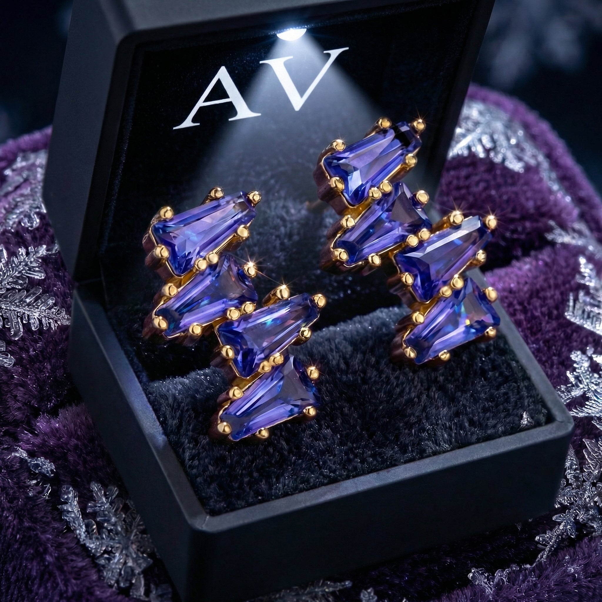 The Neriselle cluster earrings in 18K gold vermeil with simulated tanzanite presented in a lighted black gift box.