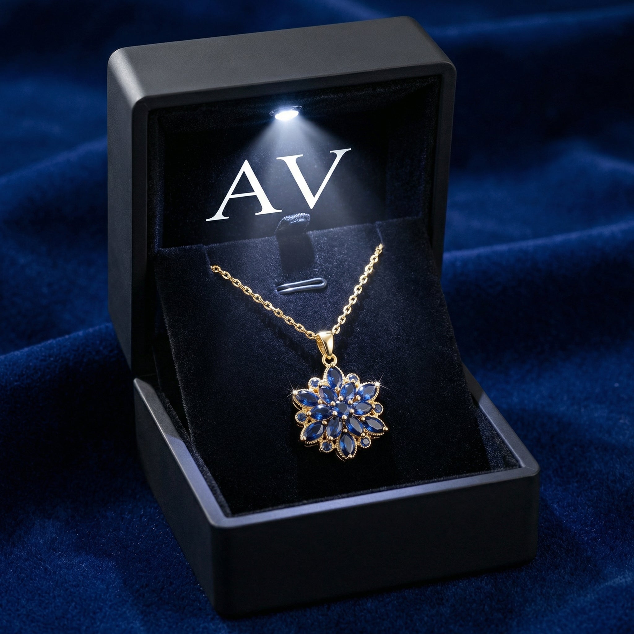Gold simulated sapphire floral necklace in a lighted black AV branded jewelry gift box.