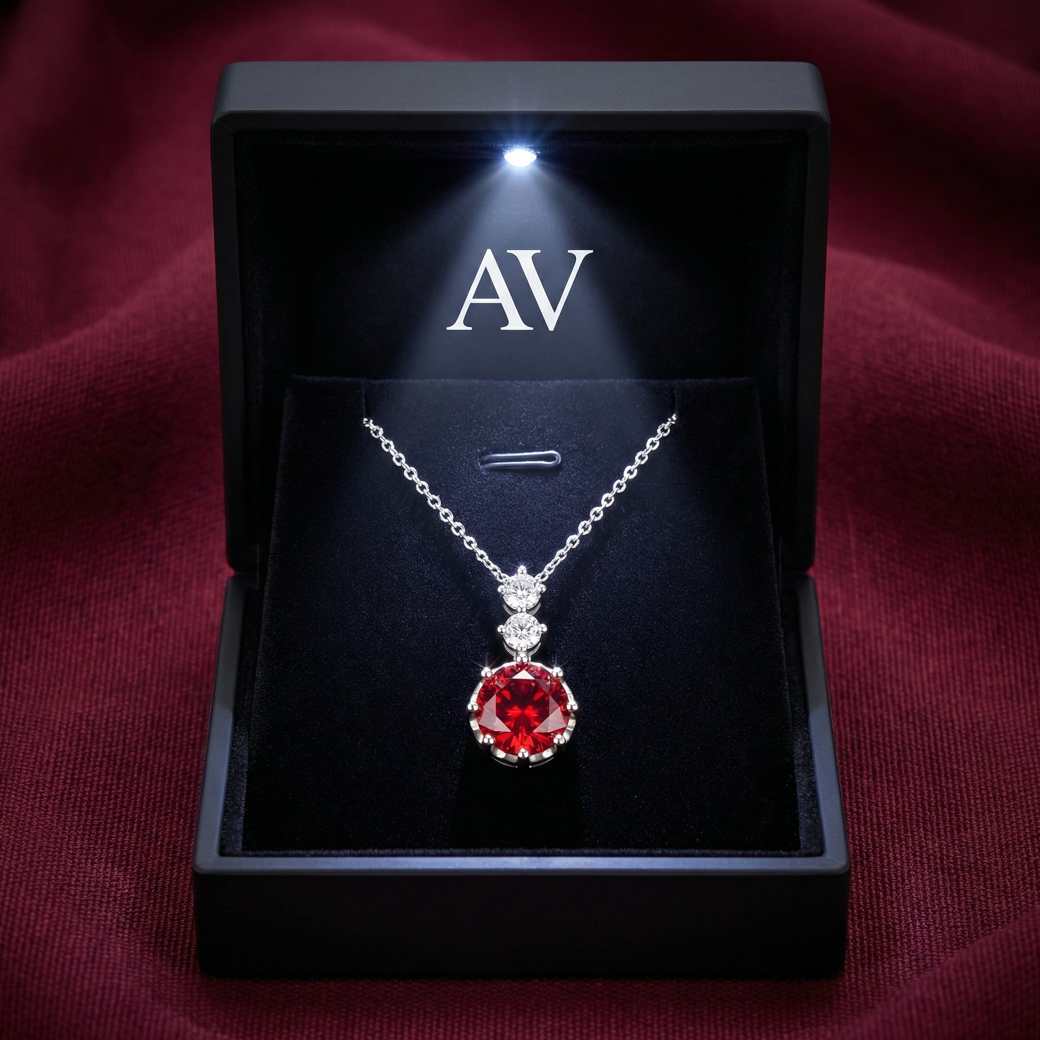 The Lucerise Drop simulated ruby necklace in sterling silver inside a black LED-lighted gift box.