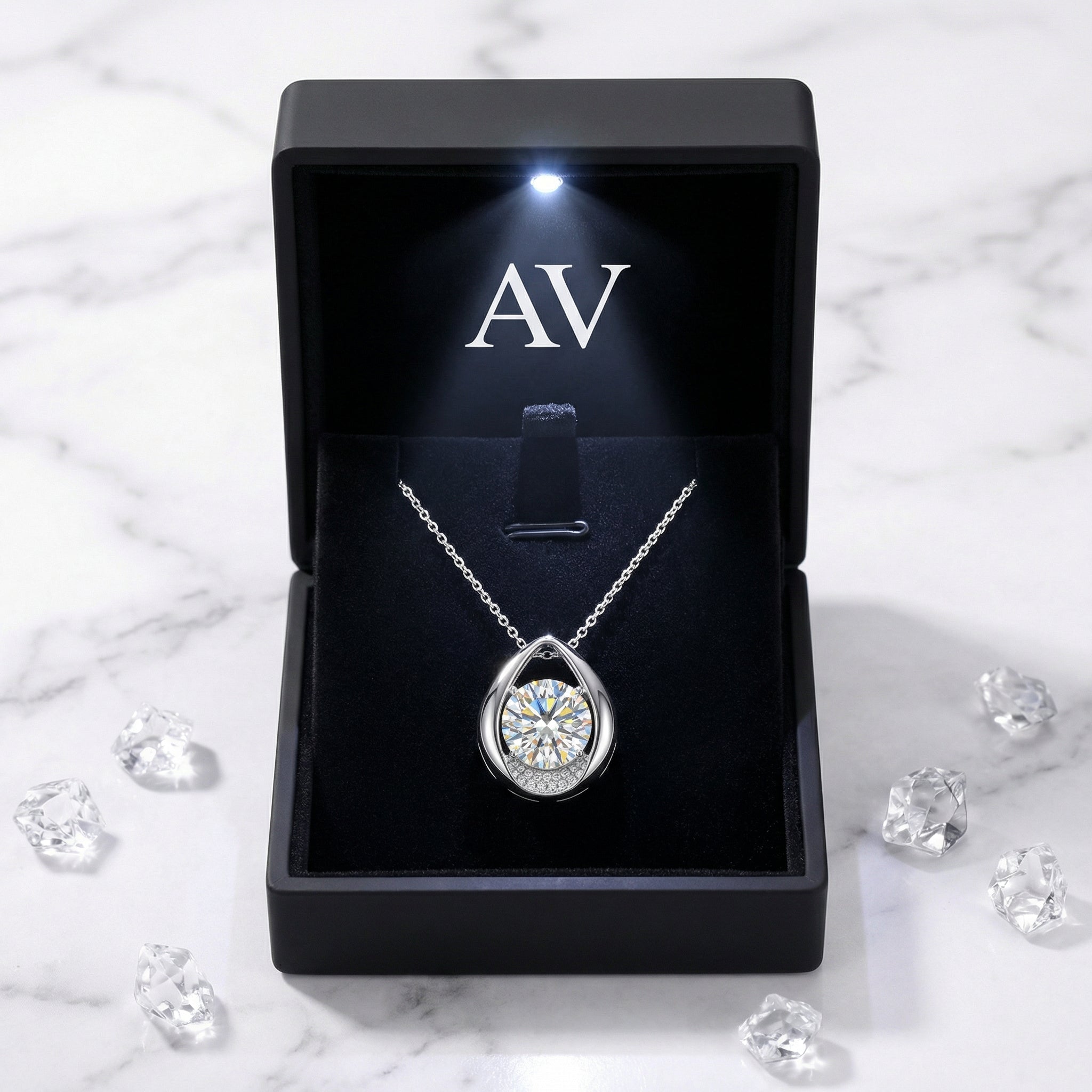 Sterling silver teardrop necklace with a round cut zirconia inside a black LED-lighted gift box.