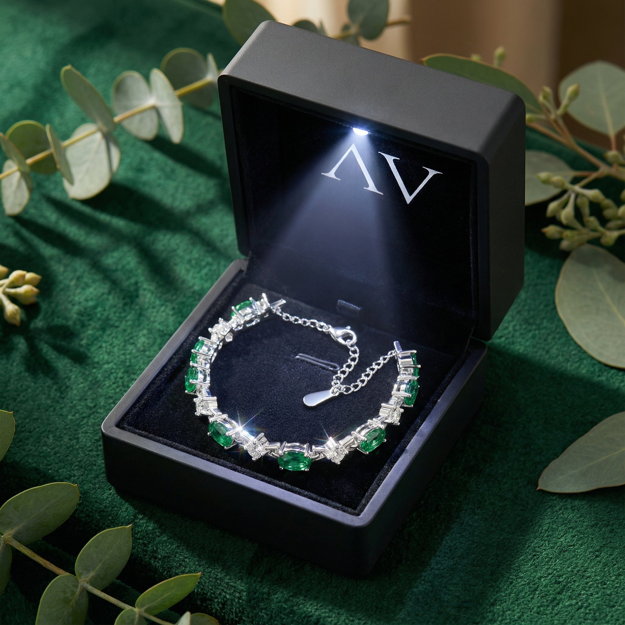 Silver oval-cut simulated emerald bracelet in a premium black gift box with an integrated LED light.