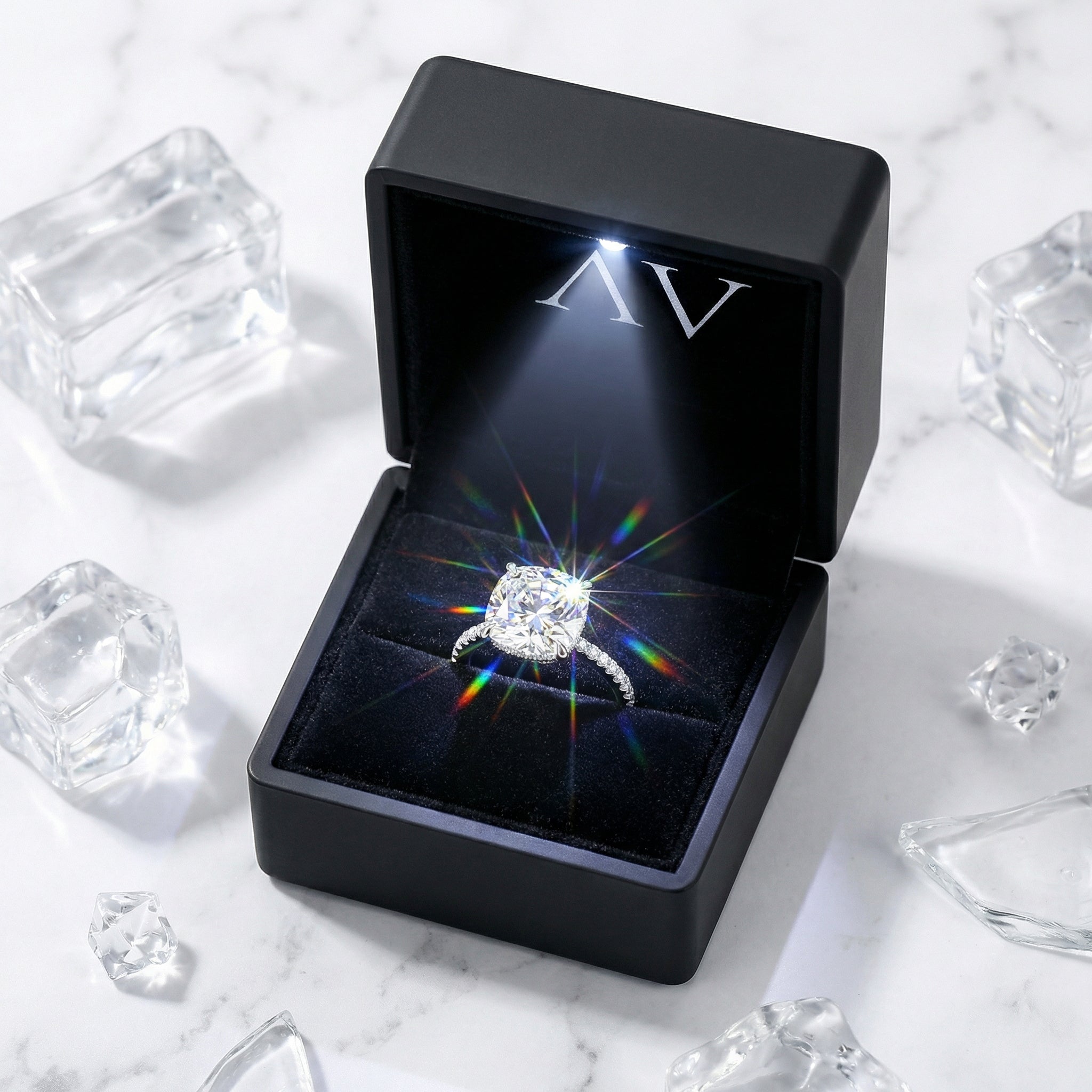 Celestina cushion cut silver ring inside a black LED-lighted gift box on a marble surface.