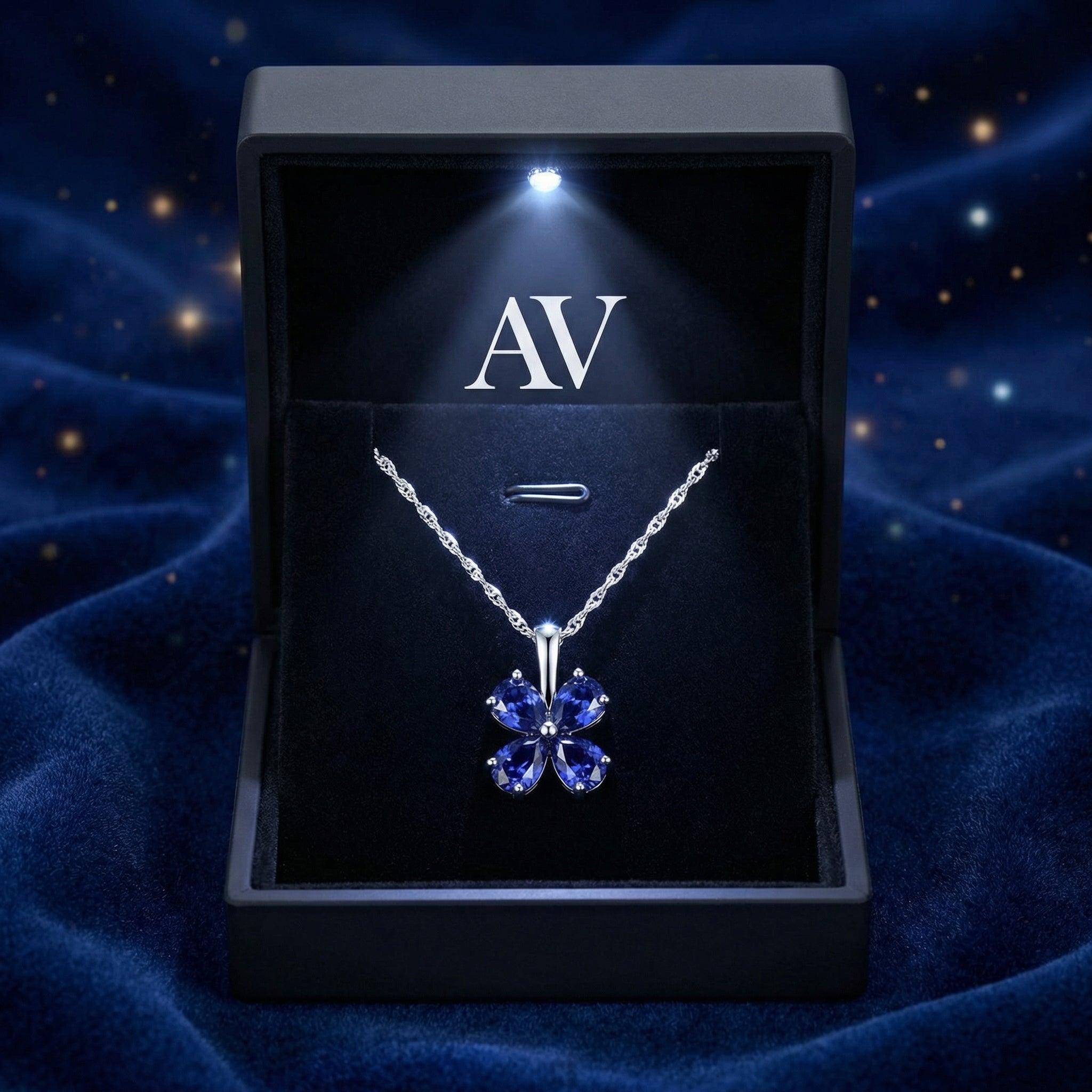 Sterling silver heart-cut simulated sapphire clover necklace inside a premium lighted black gift box.
