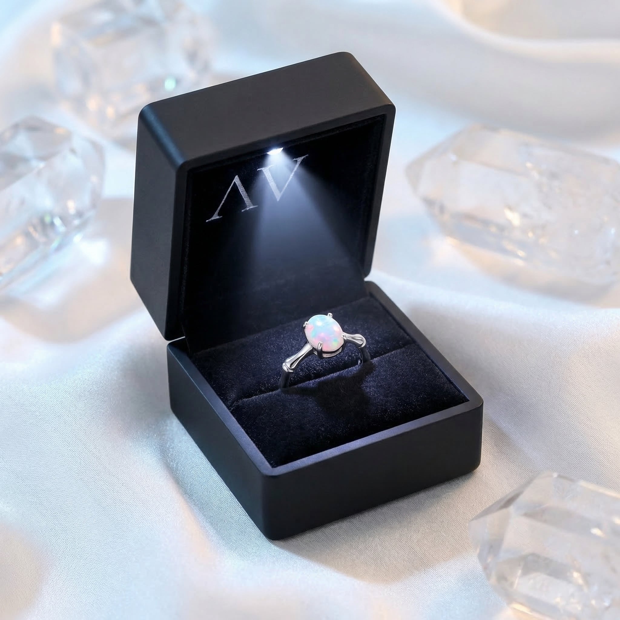 The Guinevere oval opal ring in a black LED-lit jewelry box, highlighting the stone's play-of-color.