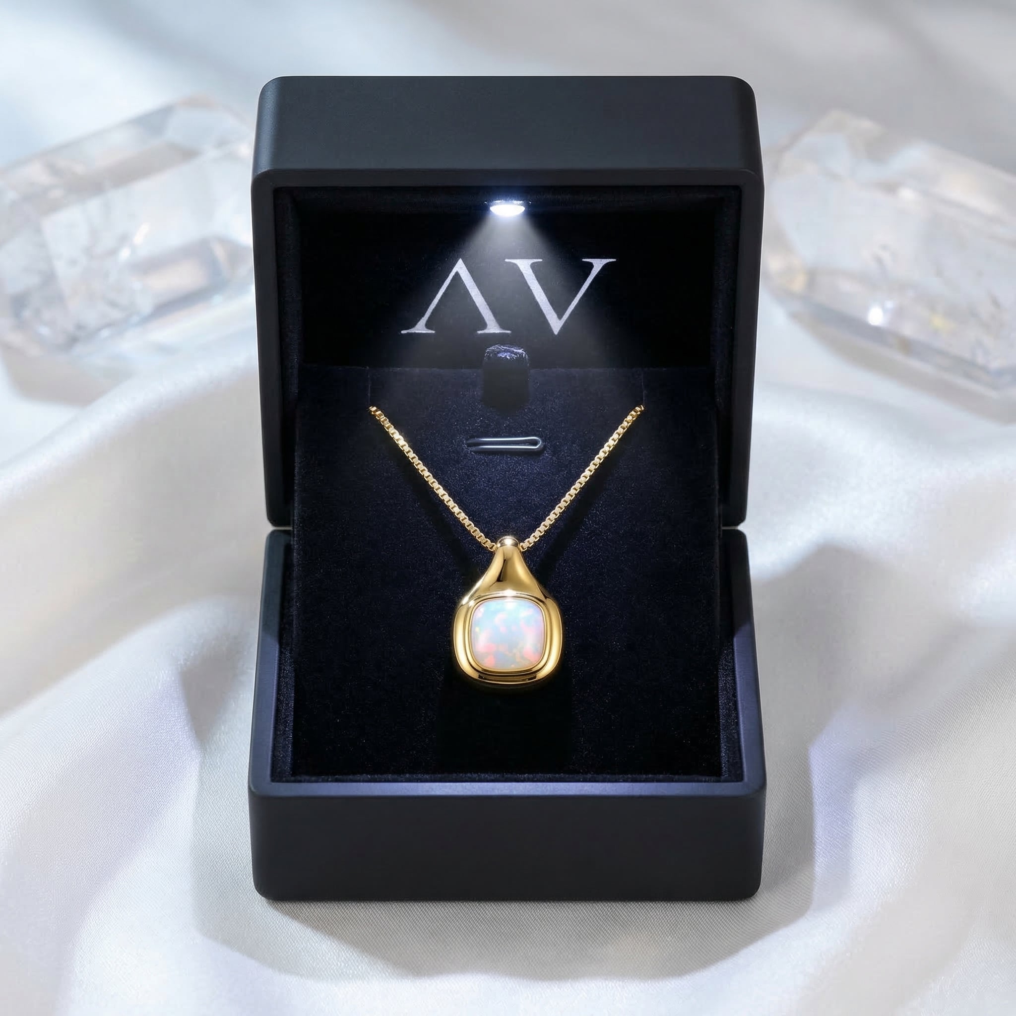 Gold vermeil cushion cut white opal necklace presented in a black illuminated jewelry gift box.