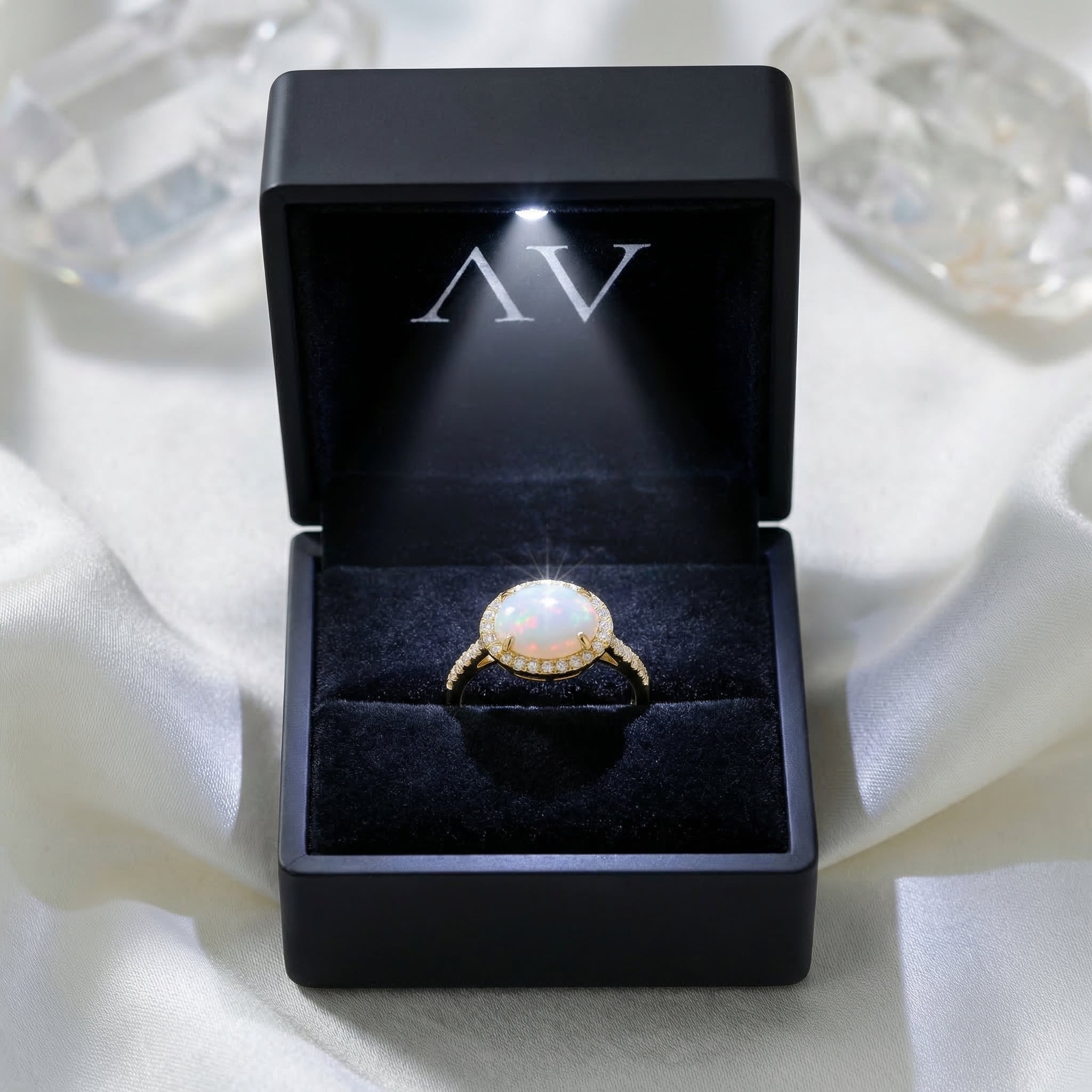 Gold vermeil Magnolia ring with an oval cut opal presented in a black LED-lit jewelry gift box.