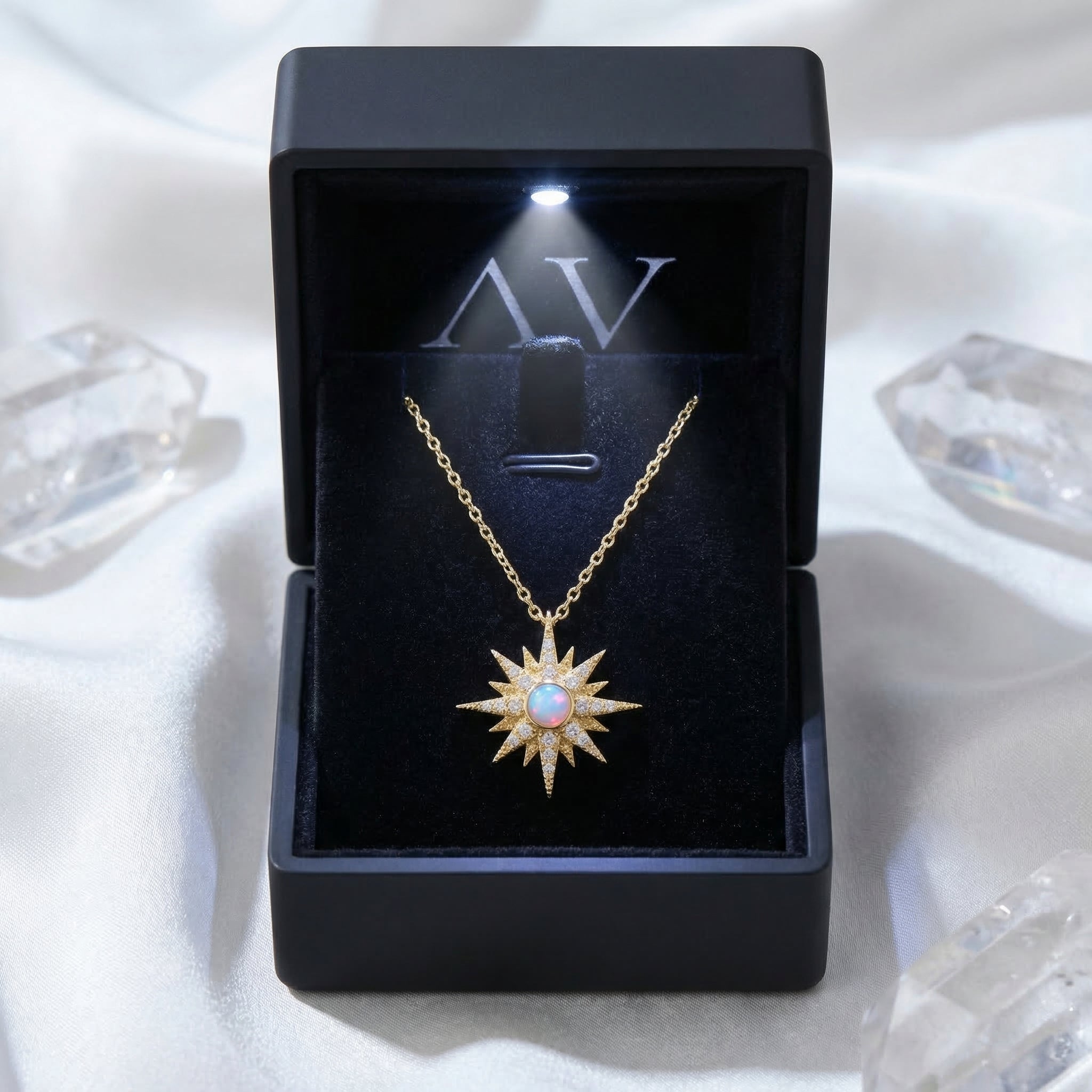 Gold Astralia starburst necklace with a white opal pendant inside a premium lighted black jewelry box.