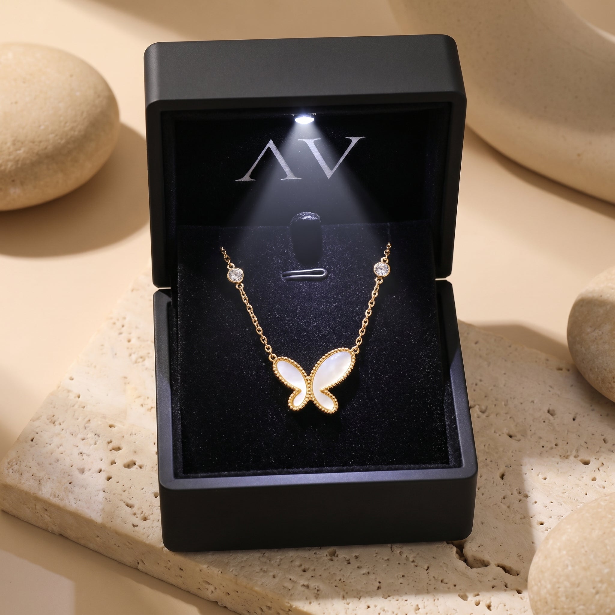 Gold butterfly necklace with mother of pearl inlay in a black LED gift box.