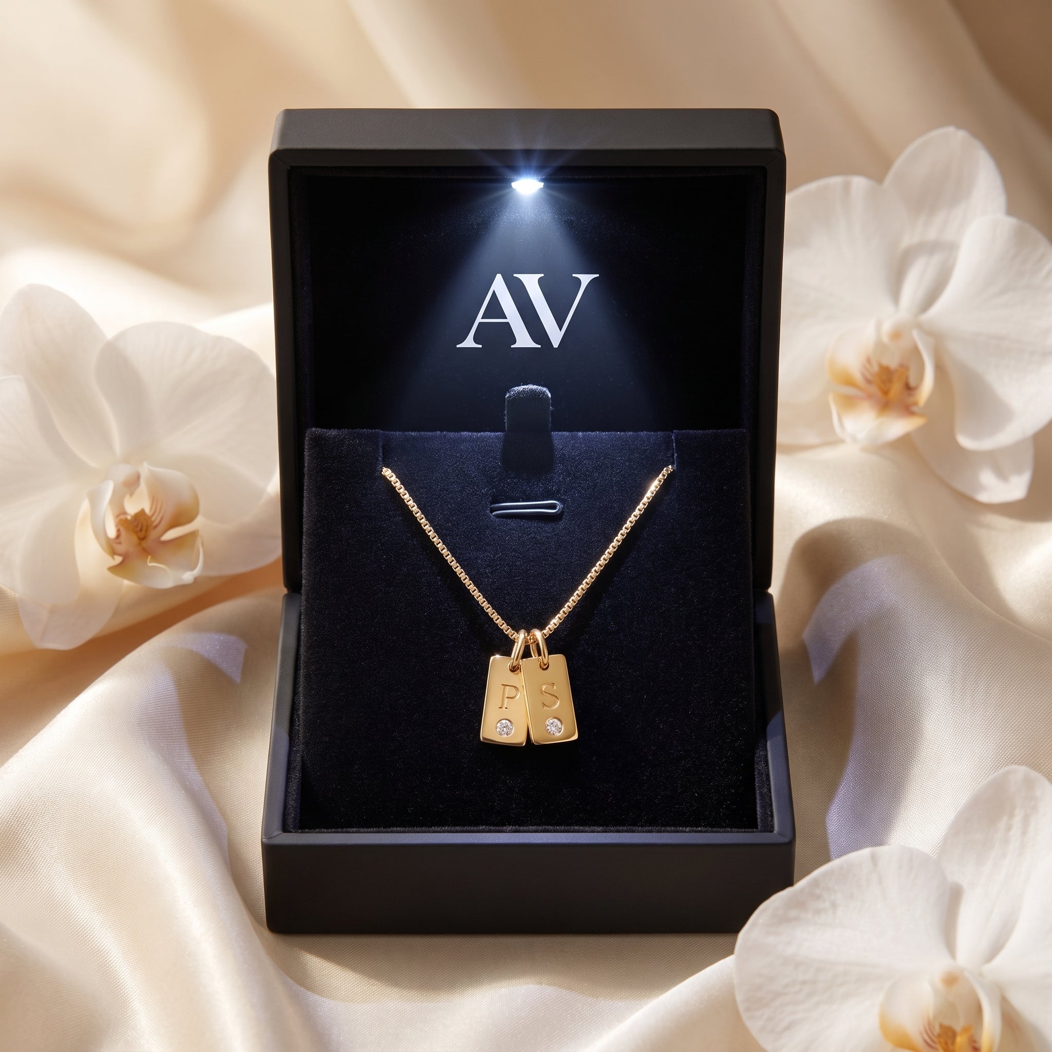 18K gold plated dual-tag initial necklace presented in a black LED-lit jewelry gift box with AV branding.