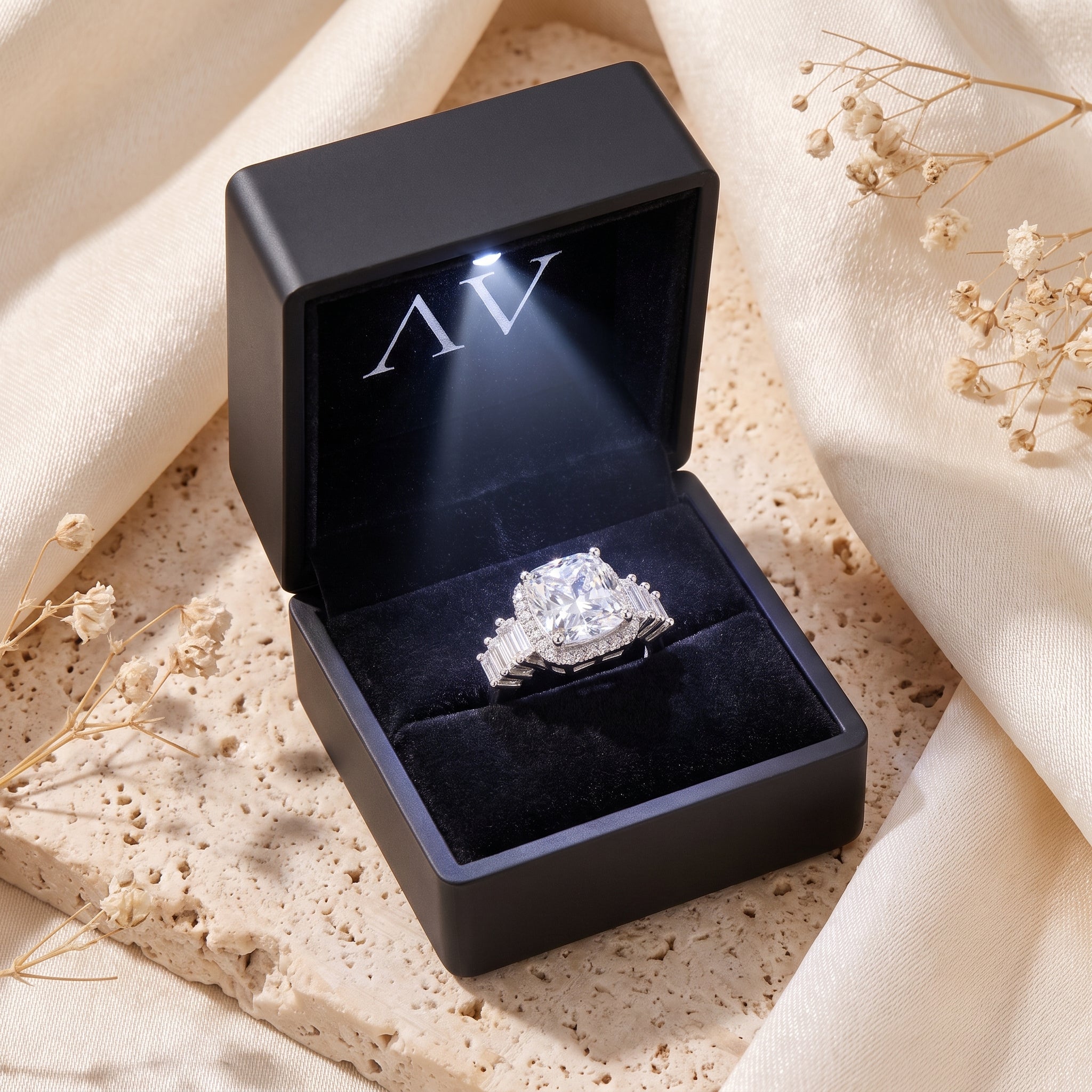 Sterling silver cushion-cut halo ring inside a black LED-lit jewelry gift box.