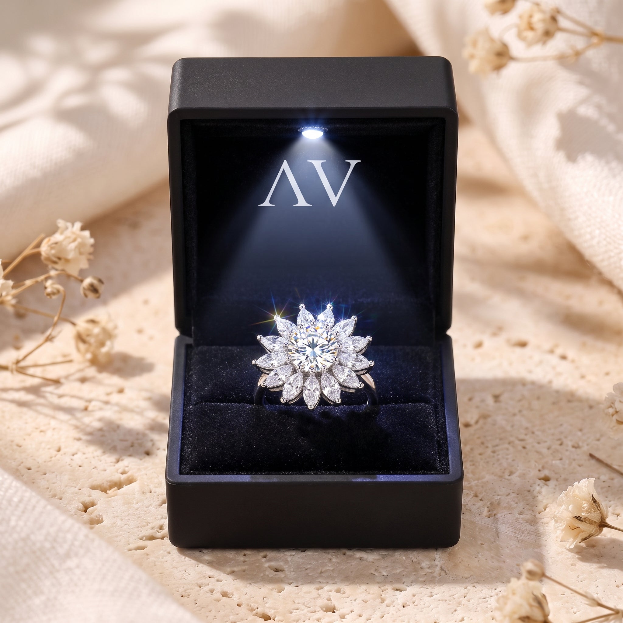 Silver sunburst halo ring presented in a black lighted jewelry box with a velvet interior.
