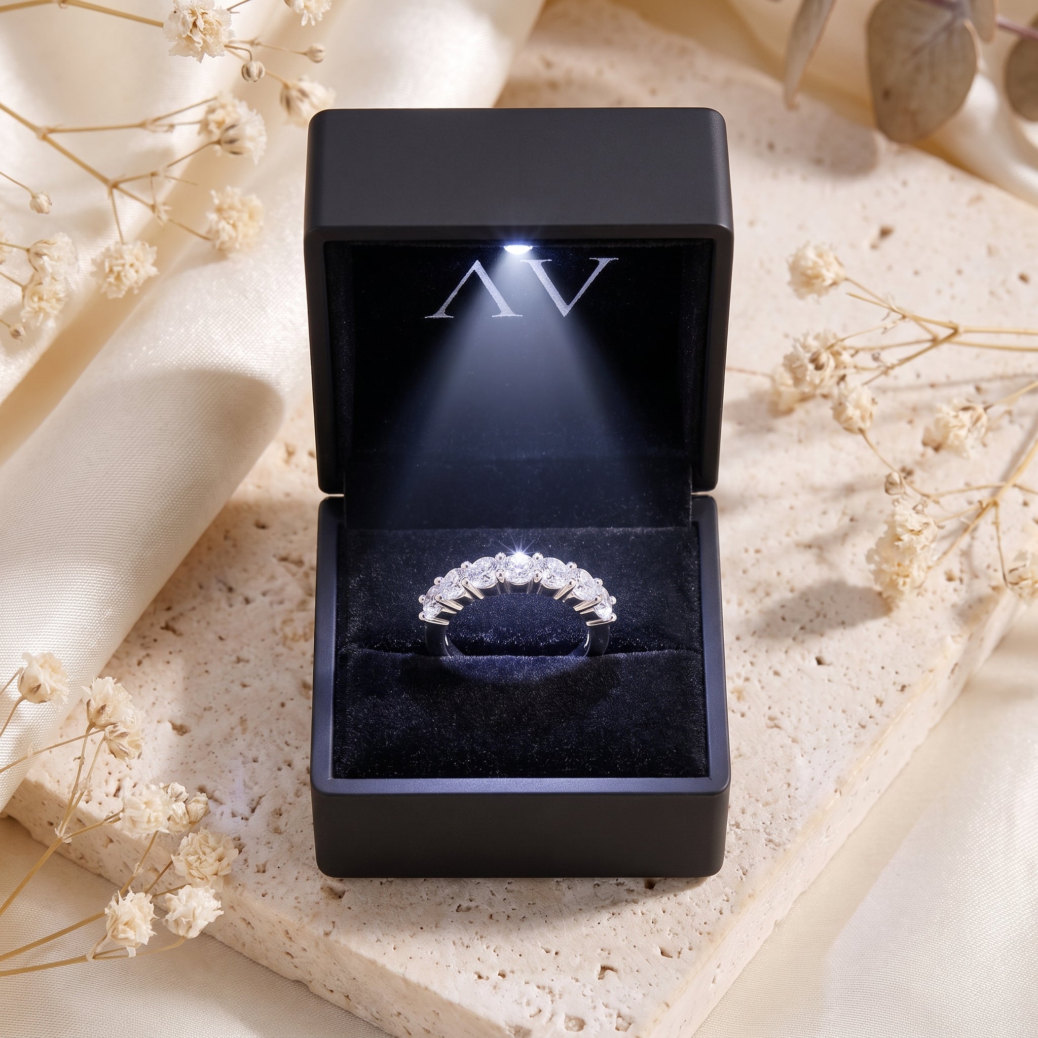 Seven-stone S925 sterling silver eternity ring displayed in a black LED-lit jewelry presentation box.