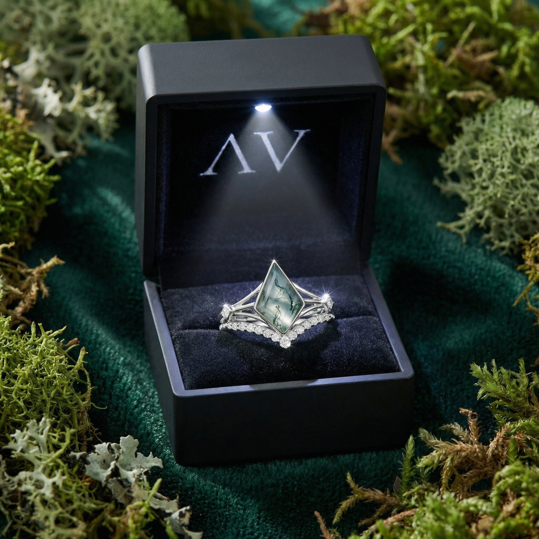 Kite cut moss agate S925 sterling silver ring set presented in a black LED-lit gift box on a mossy background.