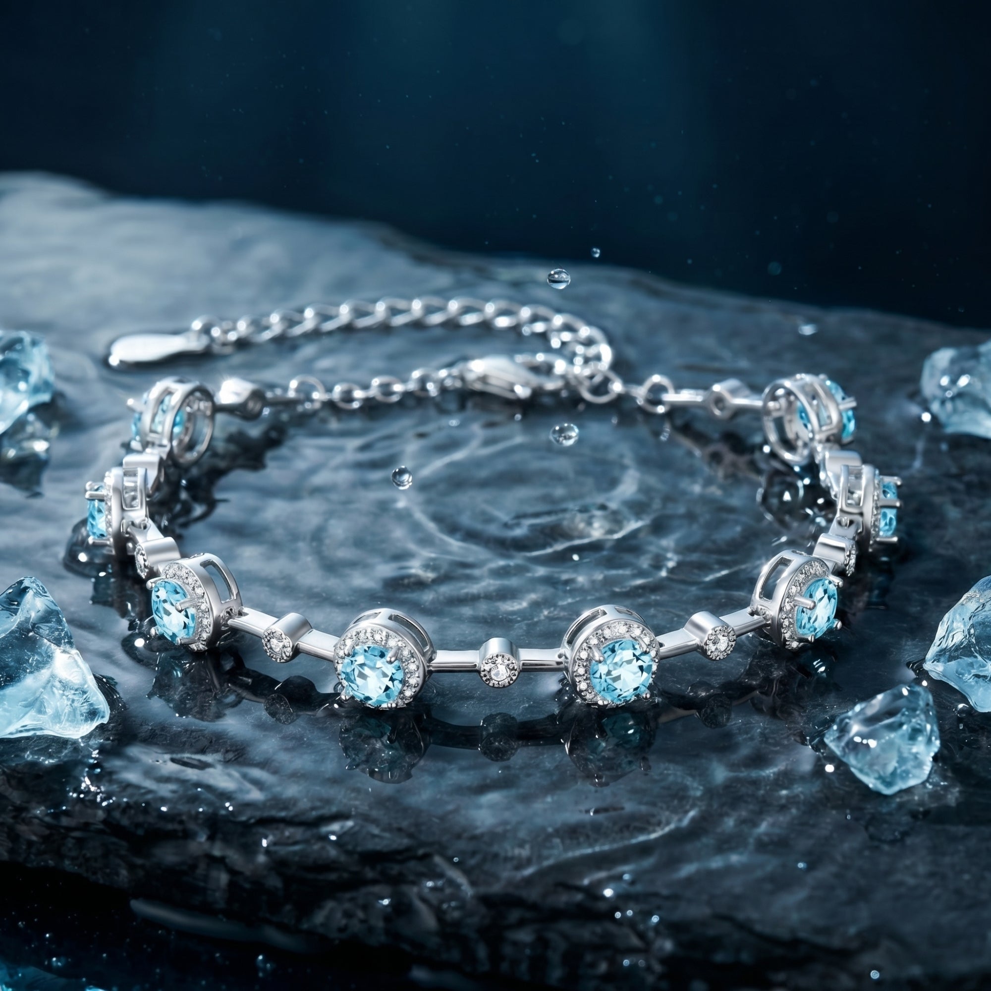 Round cut aquamarine station bracelet in sterling silver on a dark wet stone background with water droplets.