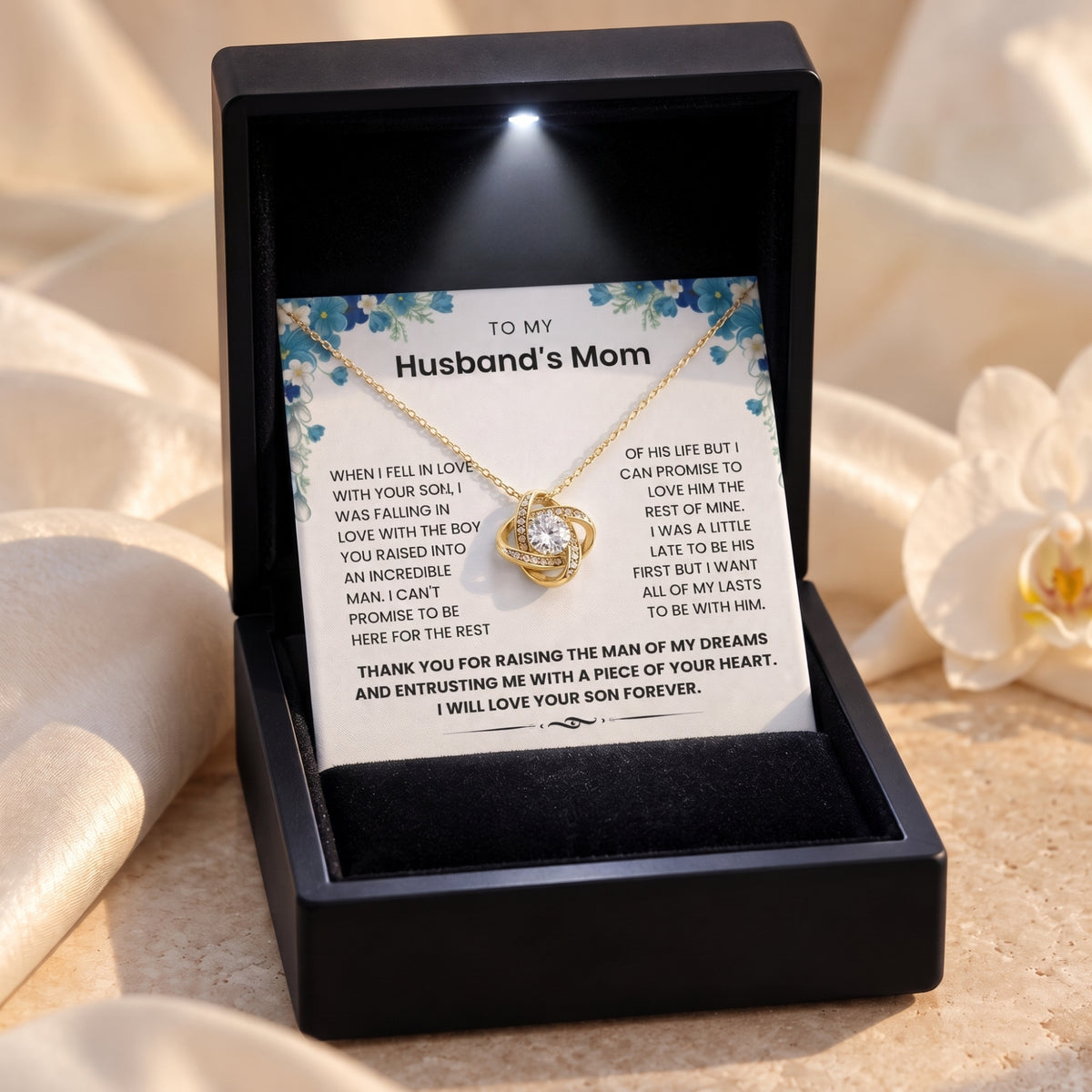 Gold-finish love knot necklace in a black LED gift box with the blue floral To My Husband’s Mom message card.