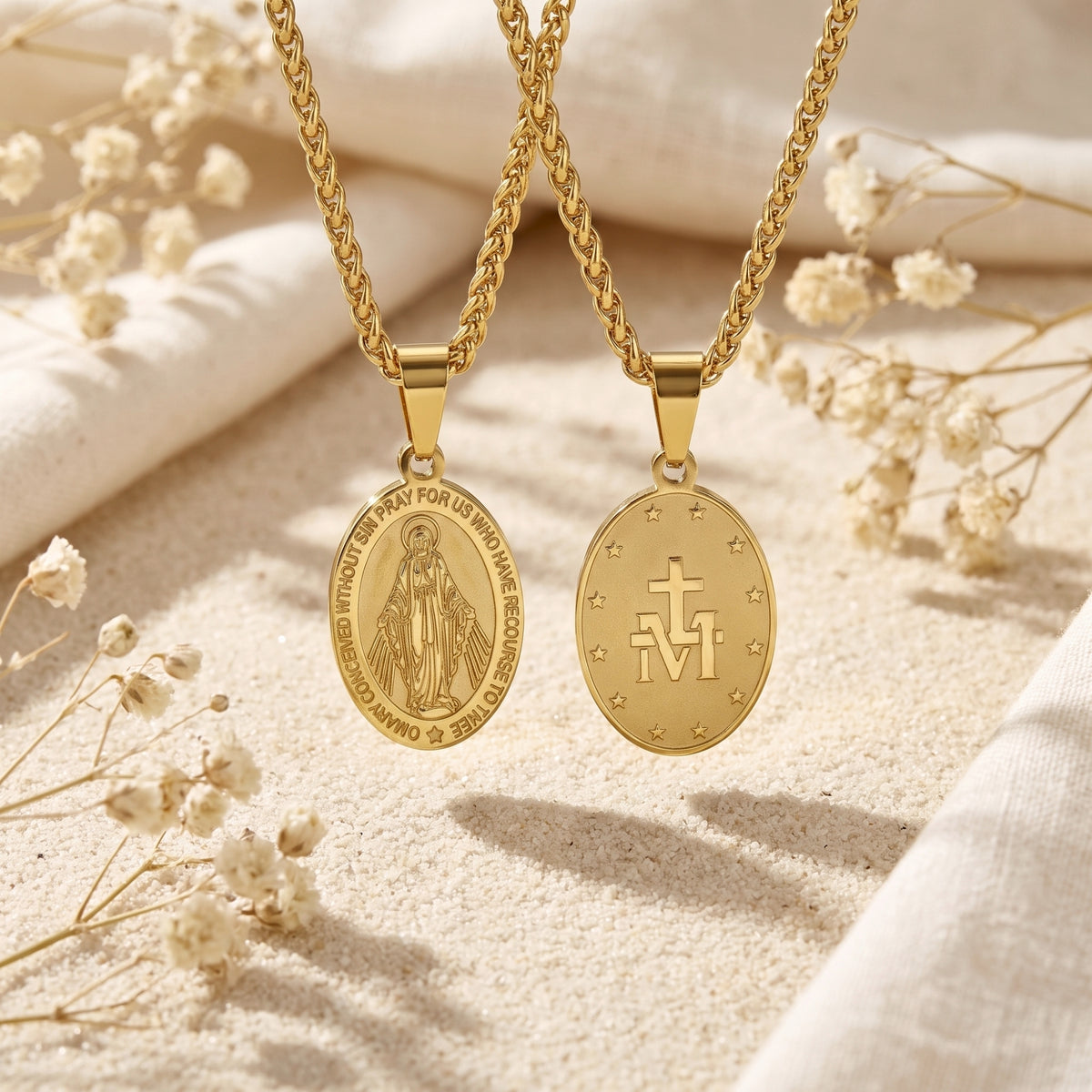 Front and back views of gold-tone oval Miraculous Medal pendants on twisted chains.