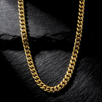 8mm gold Cuban chain in stainless steel from the Origin Collection on a dark stone background.