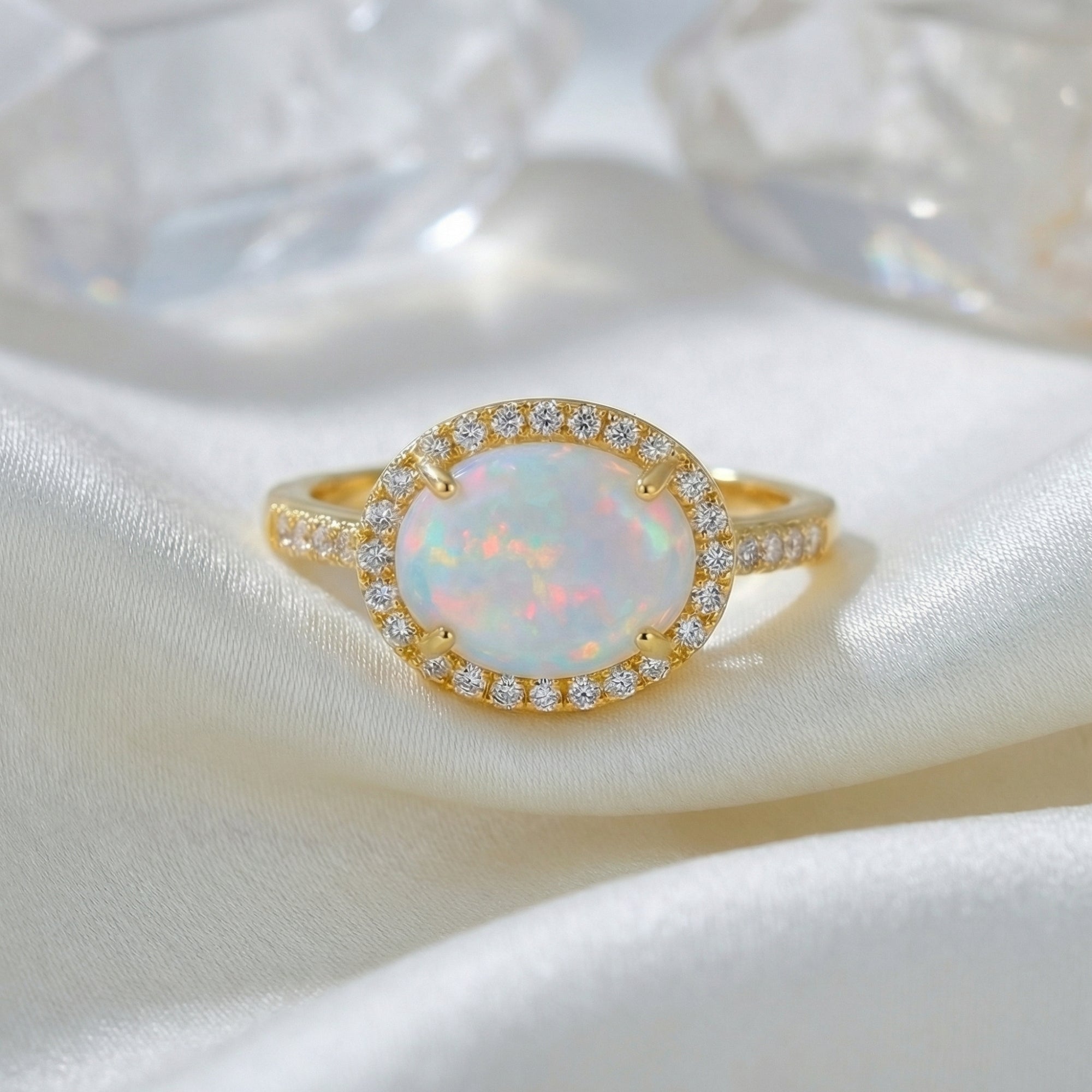 Front view of the gold vermeil Magnolia statement ring with an oval cut natural opal on white silk.