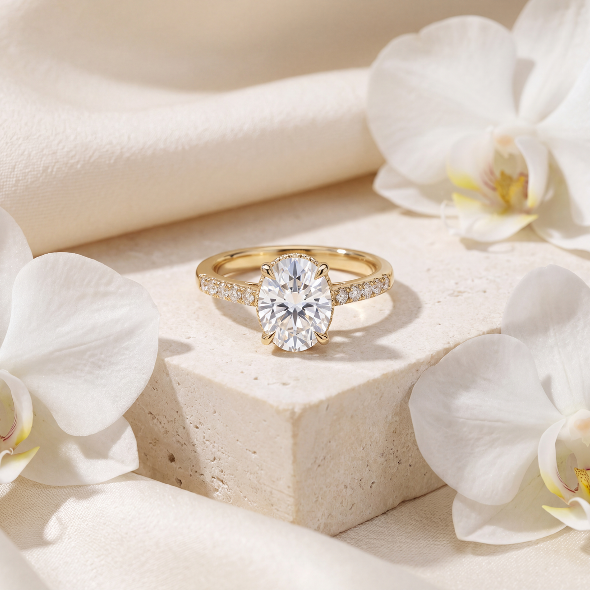Front view of an oval cut moissanite engagement ring in yellow gold with a diamond pavé band.