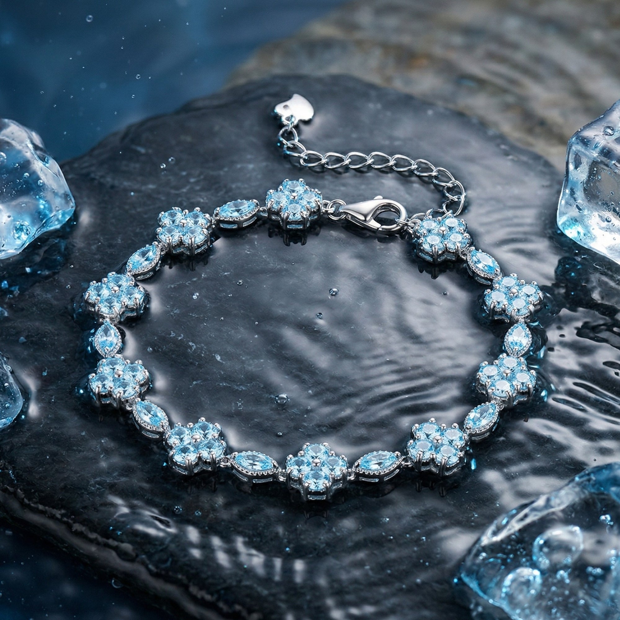 Aquamarine station bracelet in sterling silver with marquise and round stones on a wet rock with ice.