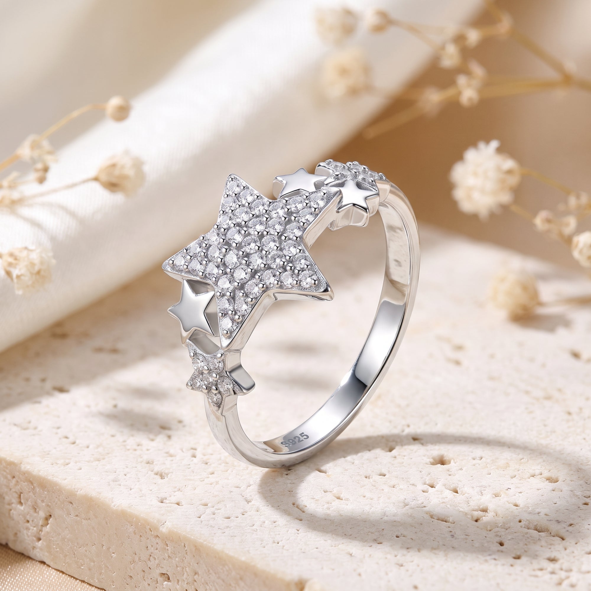 Celestia star cluster promise ring in S925 sterling silver with round simulated diamonds on a stone surface.