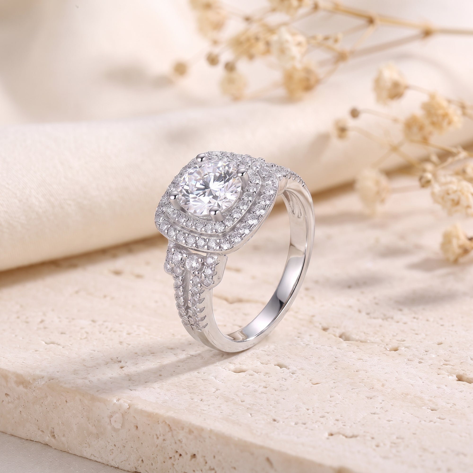 Sterling silver cushion double halo ring with cubic zirconia on a stone surface.