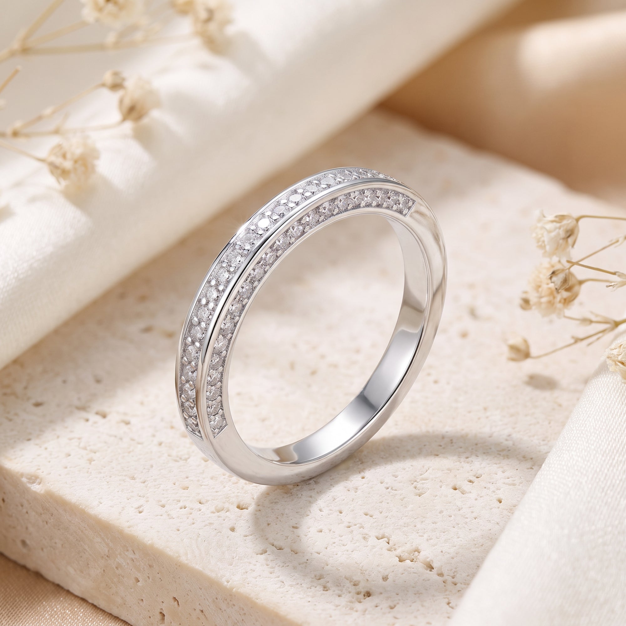 Sterling silver double row pavé ring with simulated diamonds on a stone lifestyle background.