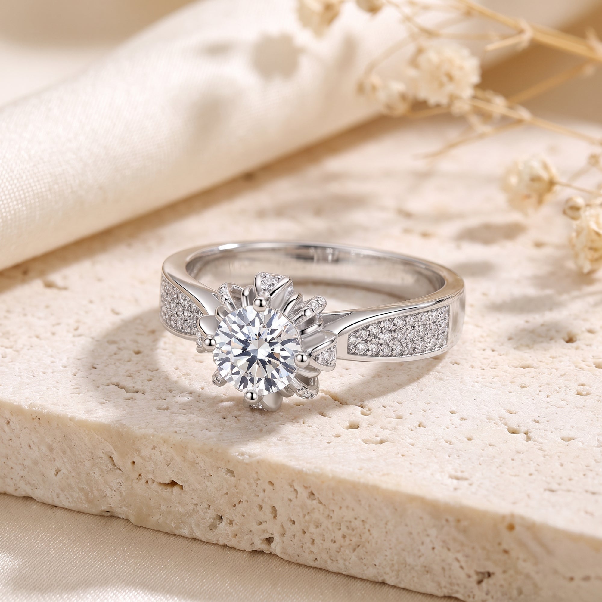 Starburst solitaire ring in S925 sterling silver with round cubic zirconia on a stone and silk background.