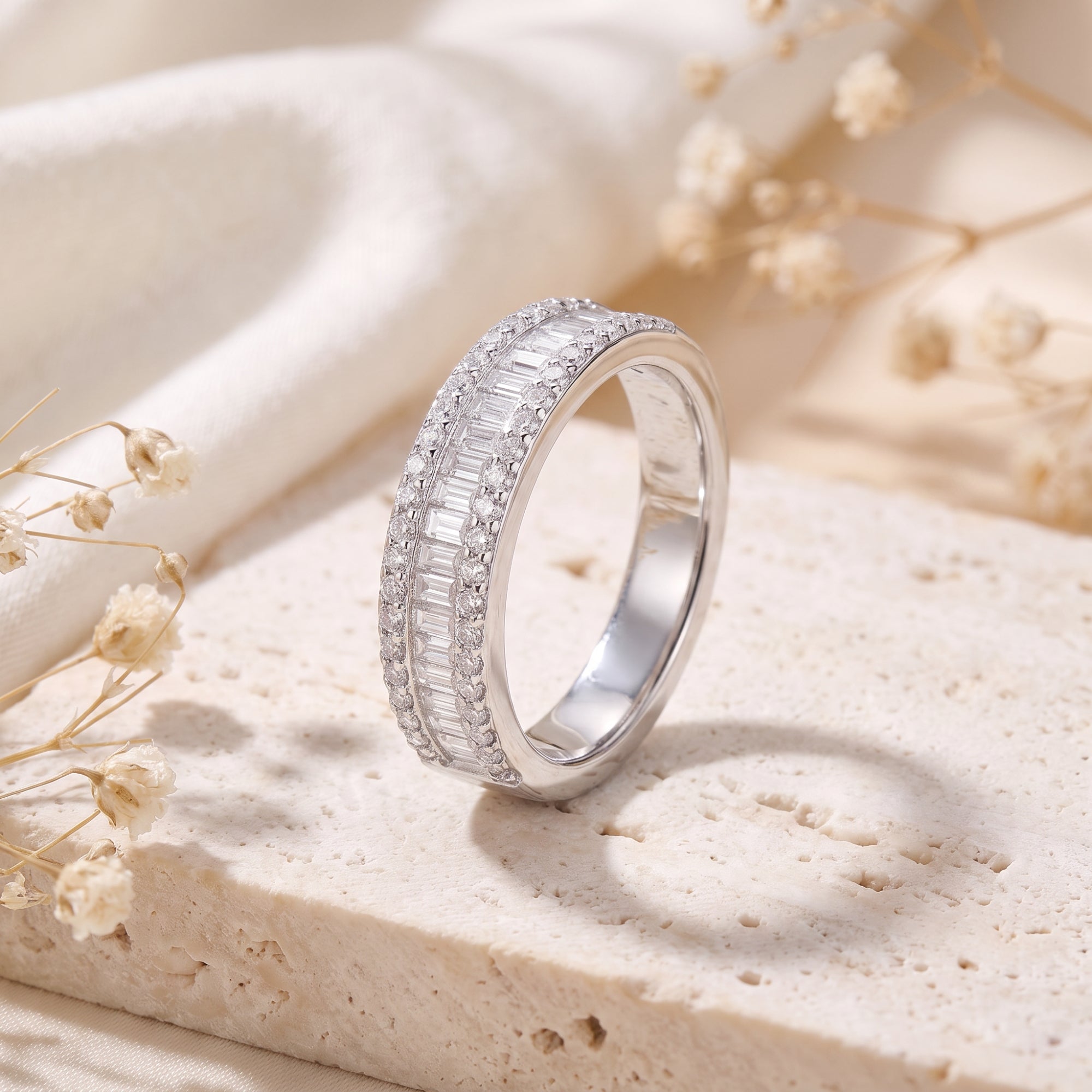 Baguette and round cubic zirconia channel-set ring in S925 sterling silver on a stone lifestyle background.