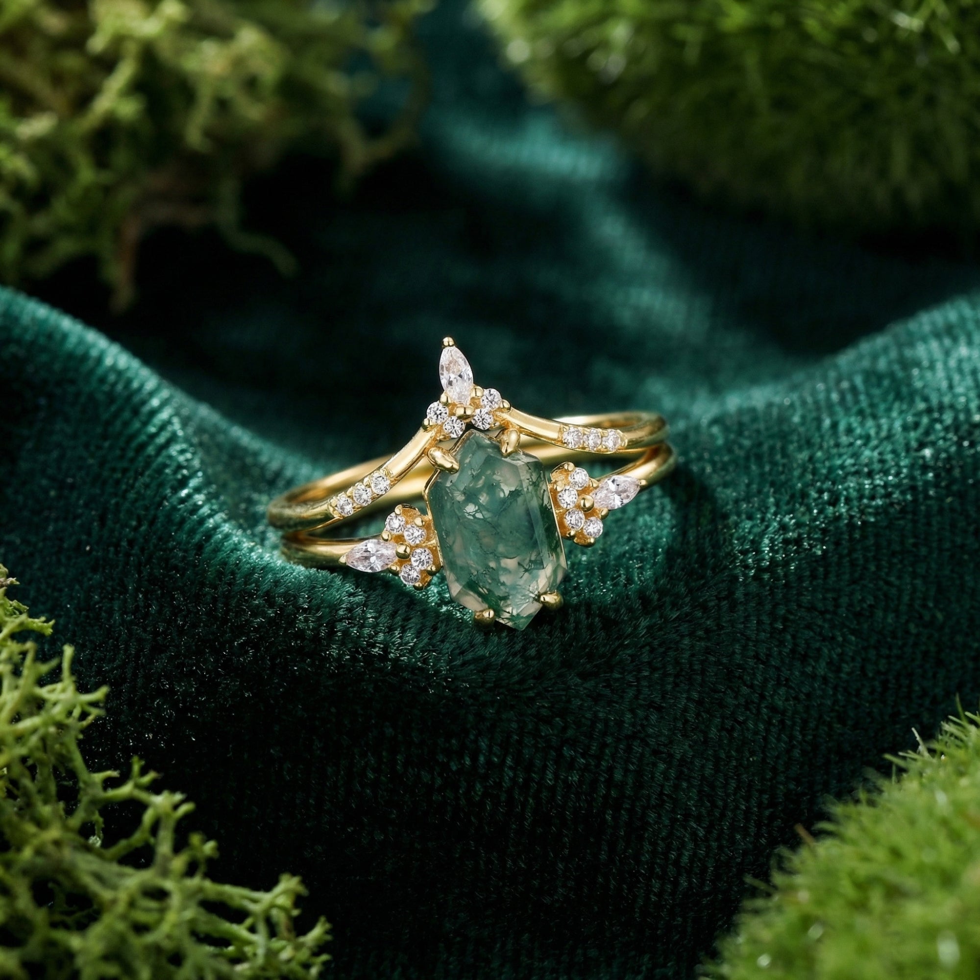 Hexagonal cut moss agate gold ring set on dark green velvet with natural moss accents.