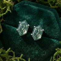 Coffin cut moss agate stud earrings in sterling silver settings on green velvet with natural moss.