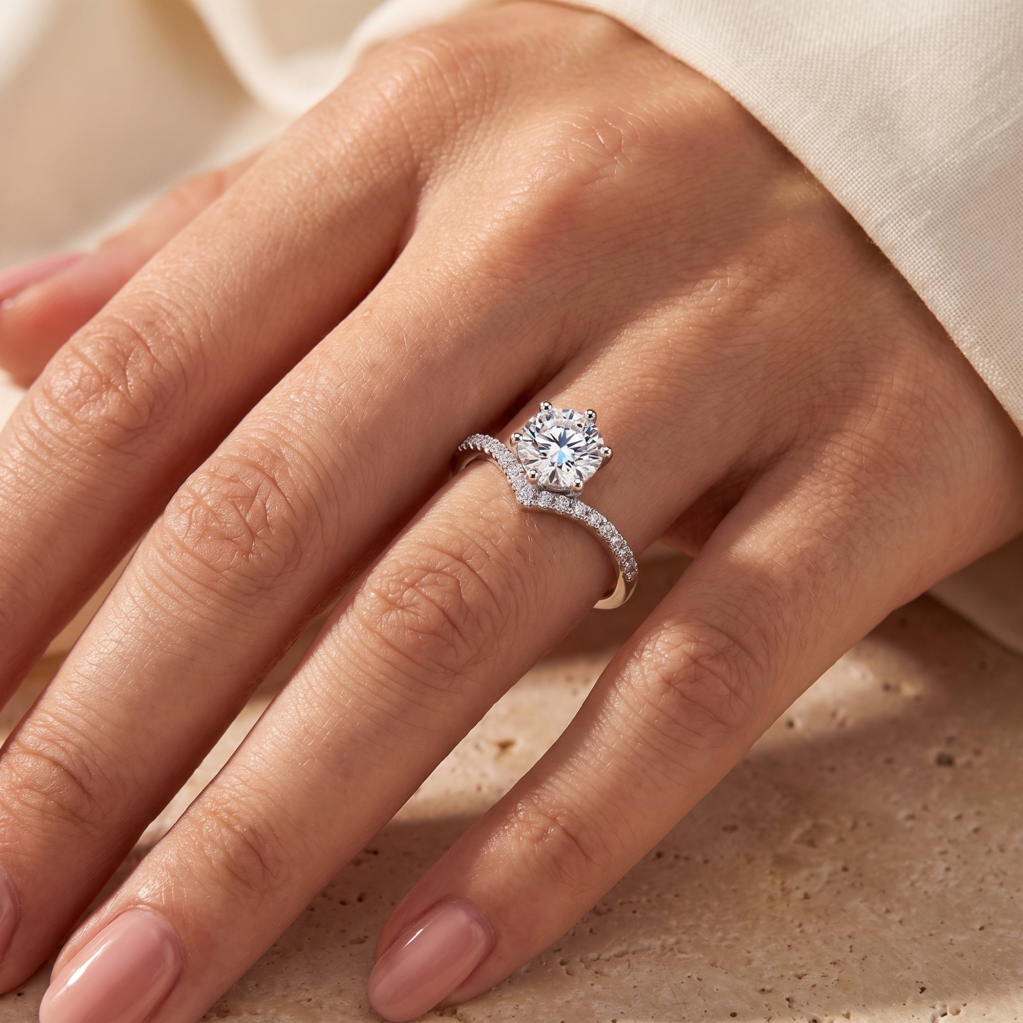 Sterling silver chevron solitaire ring with round CZ on finger.