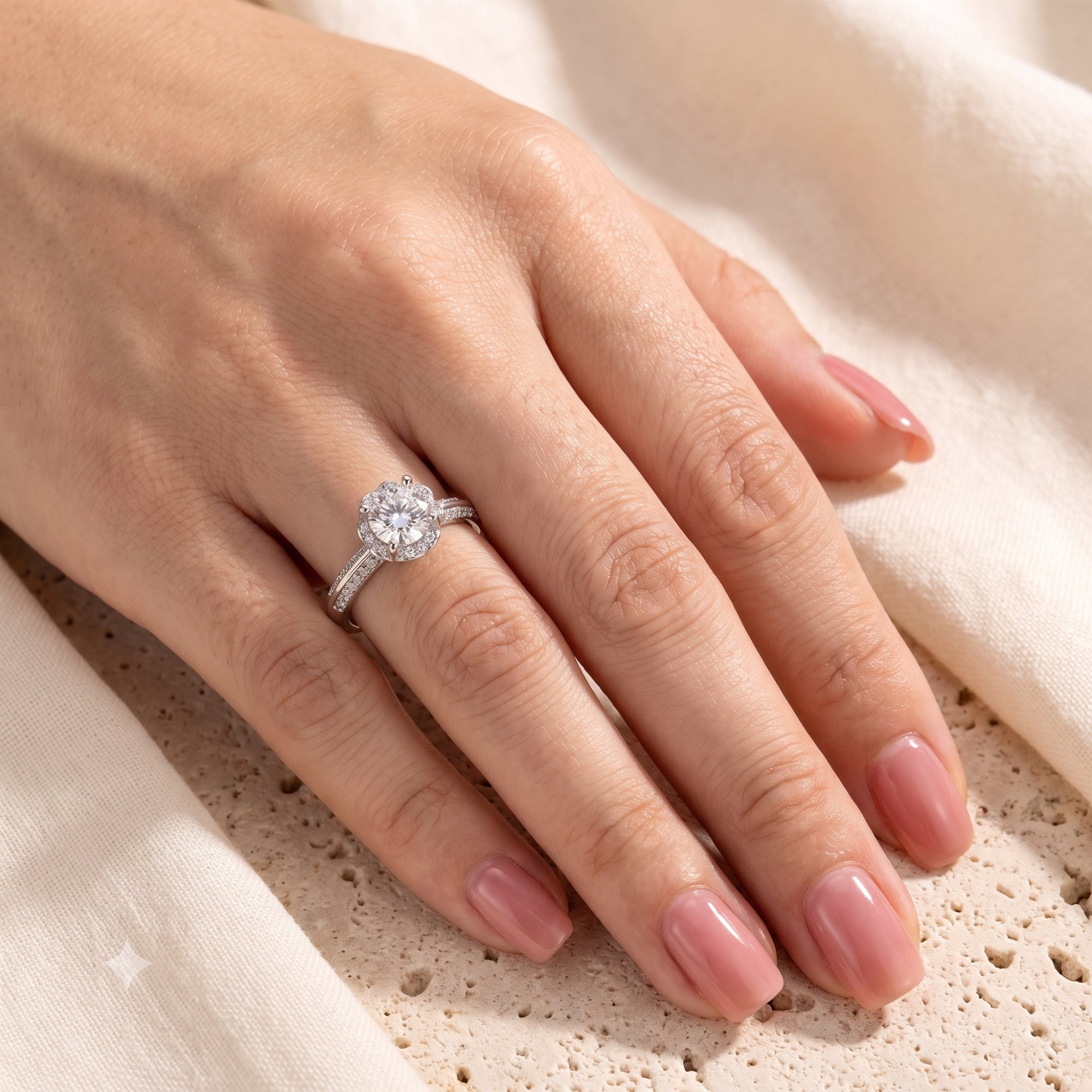 Silver simulated diamond flower ring worn on a woman's hand.