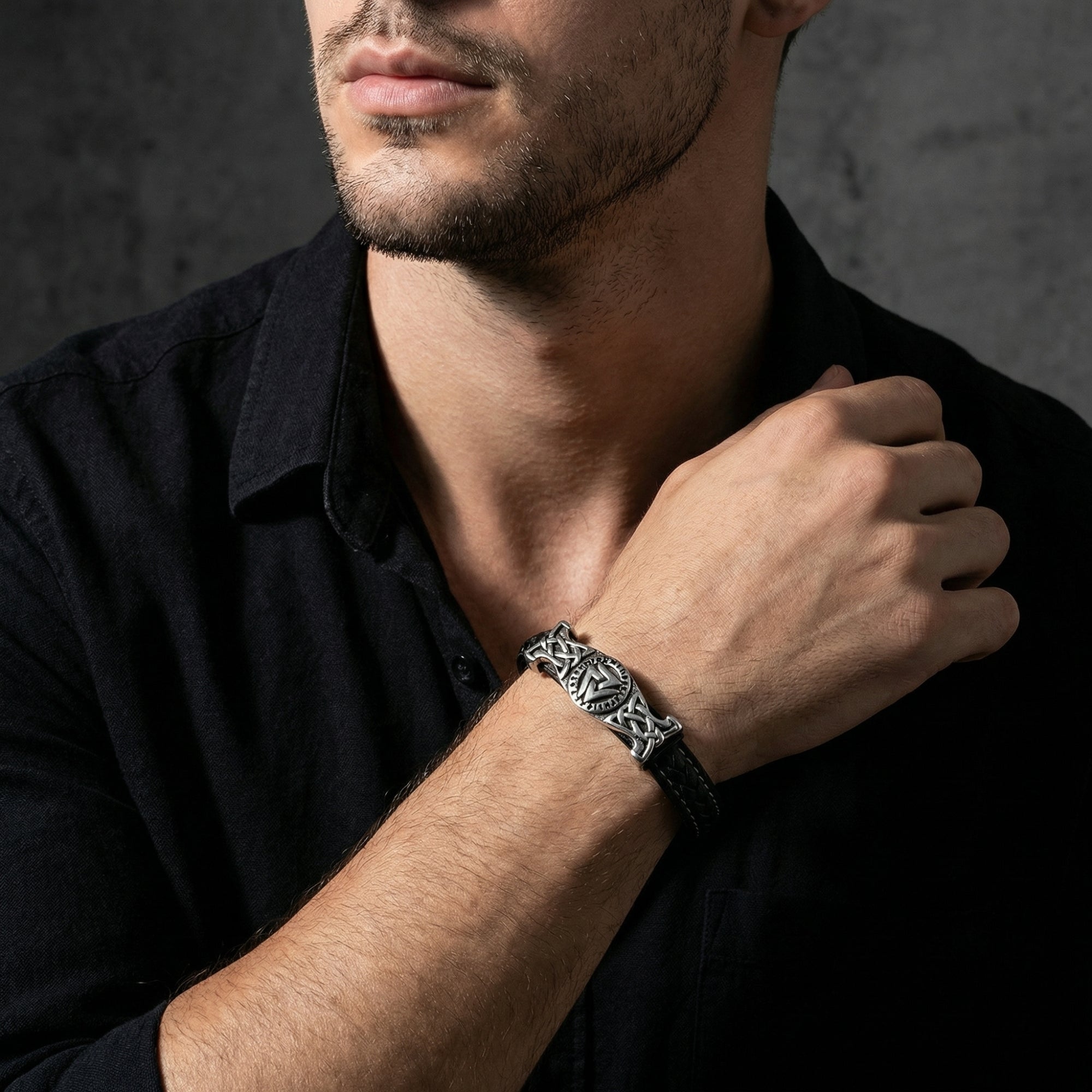 Men's black leather Runeknot bracelet with stainless steel Norse design worn on a model's wrist.