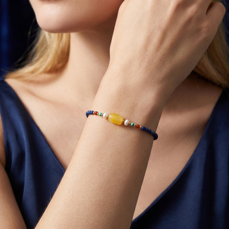 The Azure Melody lapis lazuli bracelet with 18K gold plated accents worn on a woman's wrist.