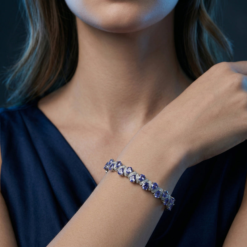 Model wearing the Kaelira pear-cut tanzanite bracelet in white gold on her wrist.