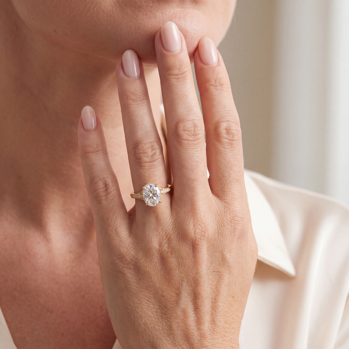 Lifestyle view of the yellow gold oval moissanite ring worn on a model's hand.