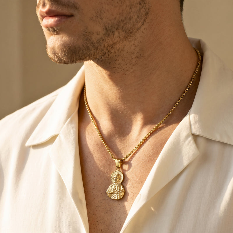 Close-up side view of a man wearing the gold finish sacred relic pendant on a box chain.