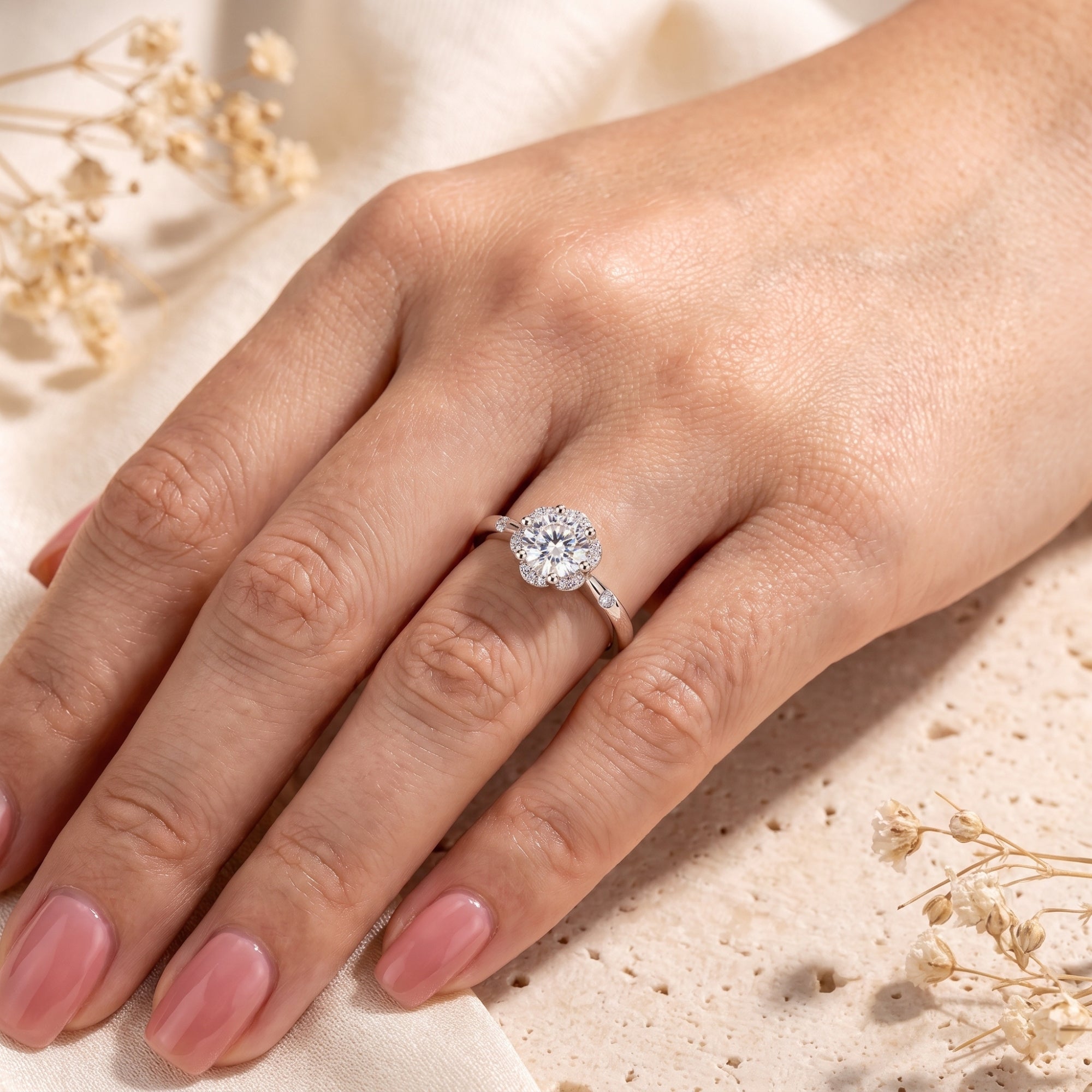 Round cubic zirconia halo ring in sterling silver worn on a hand.