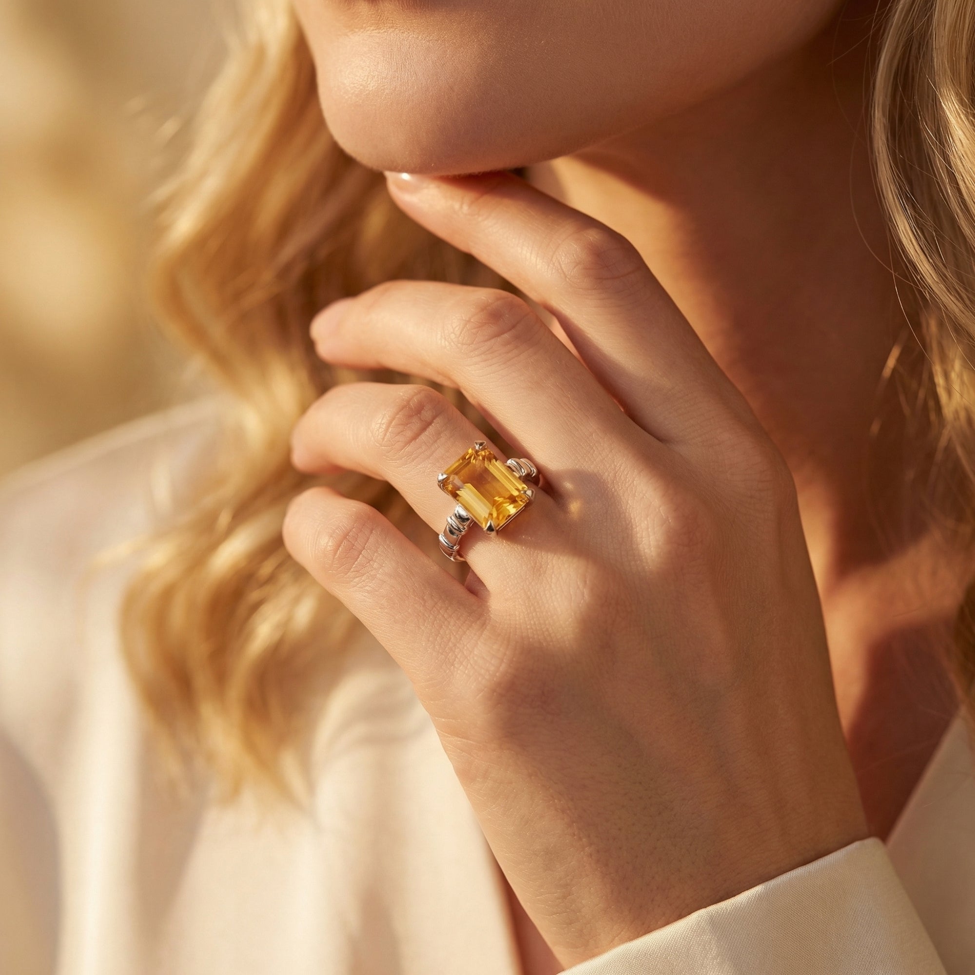 Woman wearing the Apollonia emerald cut citrine ring in silver on her finger.